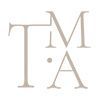 Elegant TMA monogram logo in beige tones with decorative serif typography on white background.