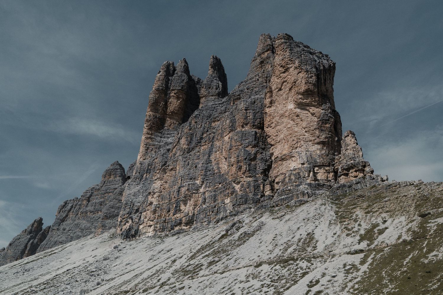Dramatic rocky Dolomite peaks with jagged spires rising above a snow-dusted alpine landscape.