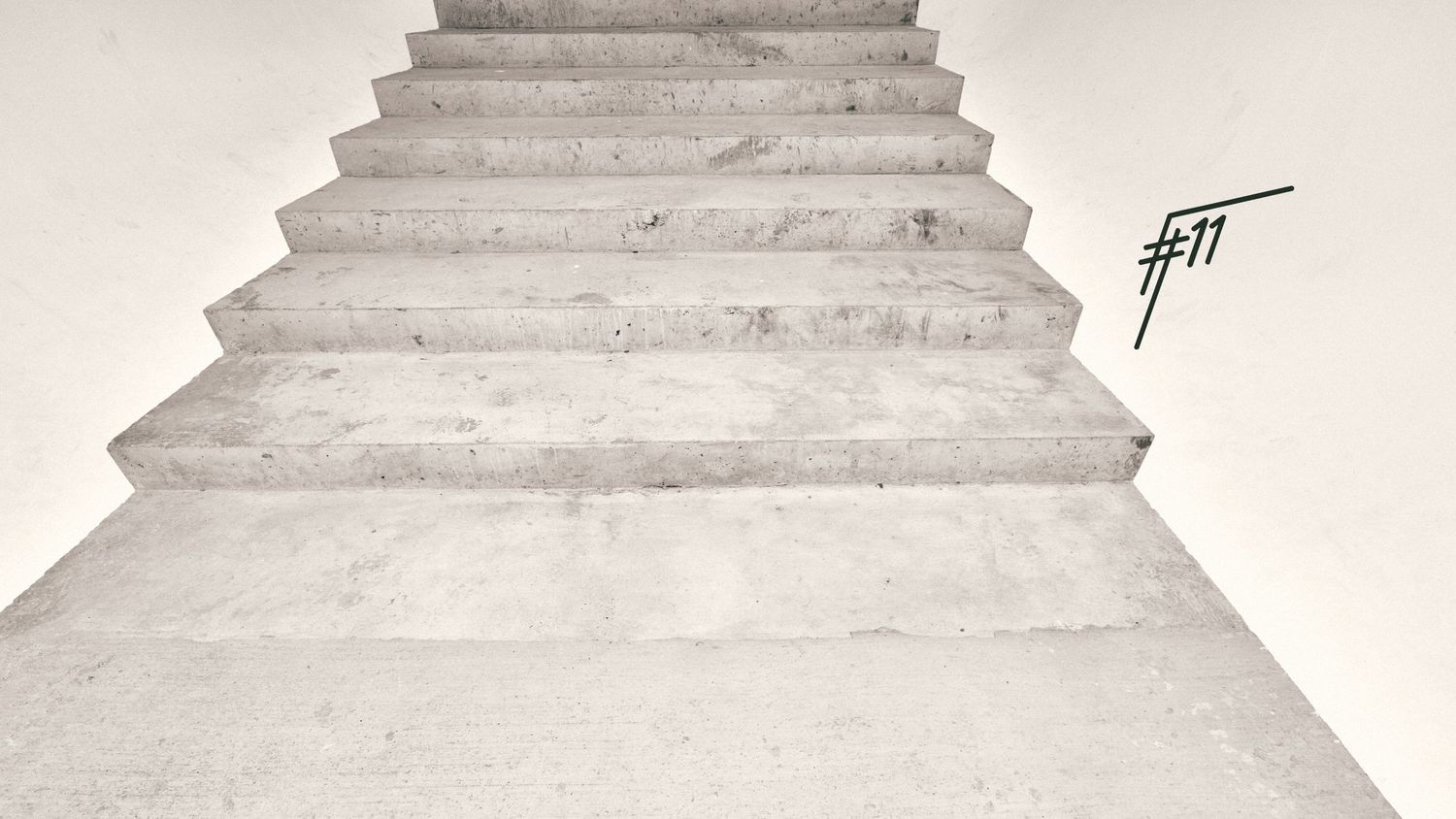 Minimalist white concrete staircase with handwritten FT logo graffiti.