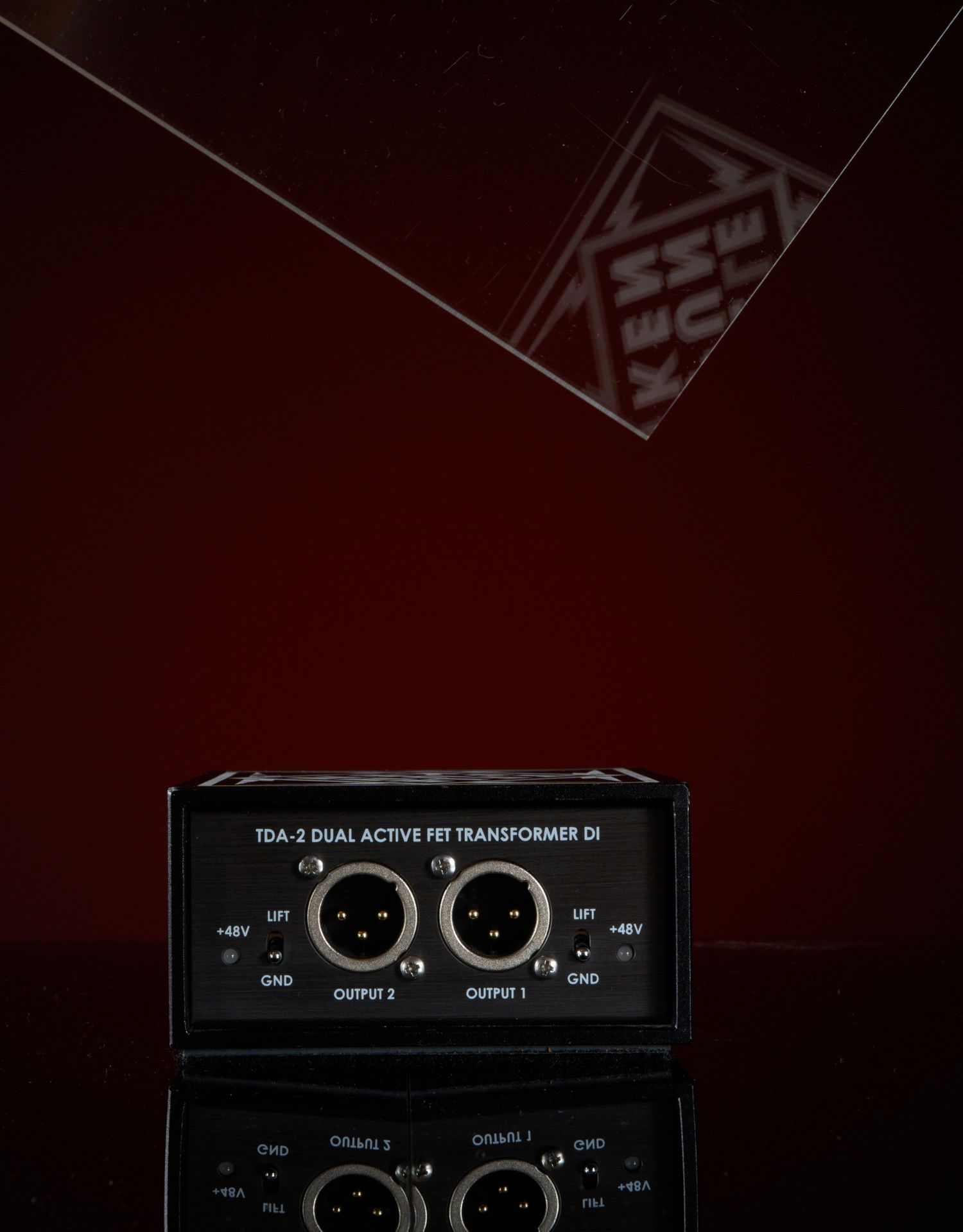 Telefunken TDA-2 Dual Active FET Transformer DI box with dual XLR outputs on reflective dark red surface.