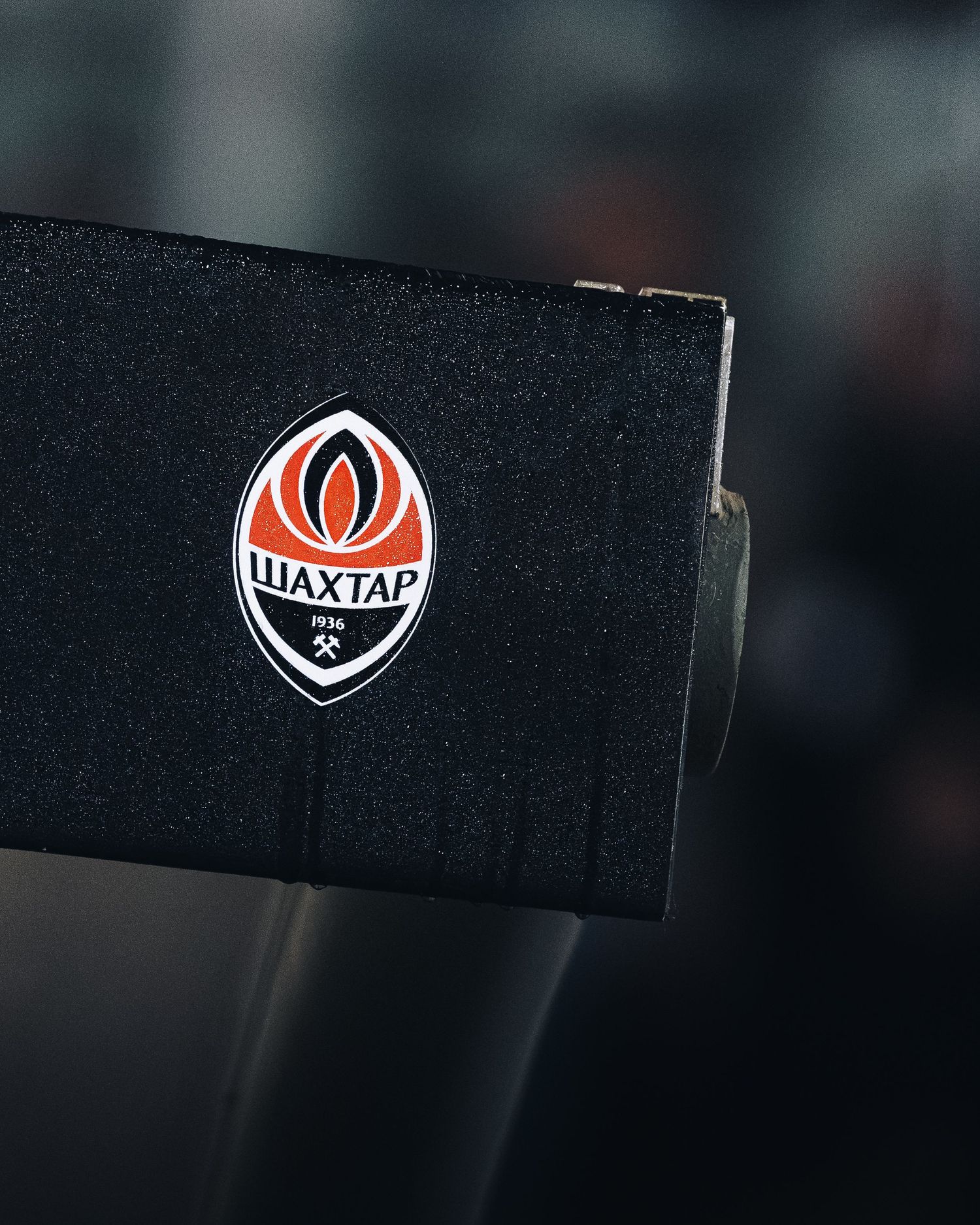 Close-up of Shakhtar Donetsk club crest on black equipment at UEFA Conference League venue.