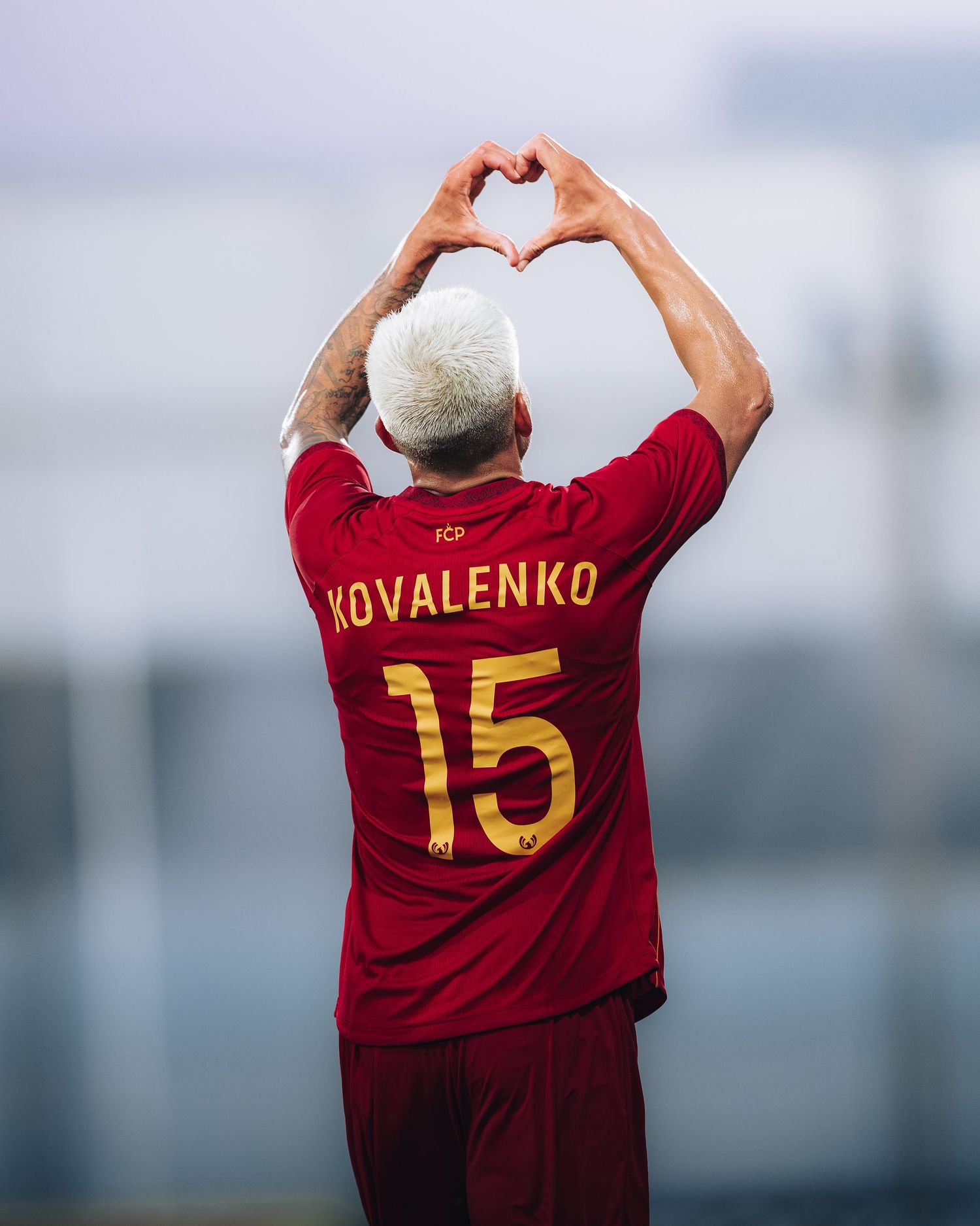 Kovalenko number 15 in red jersey making heart shape with hands raised above head.