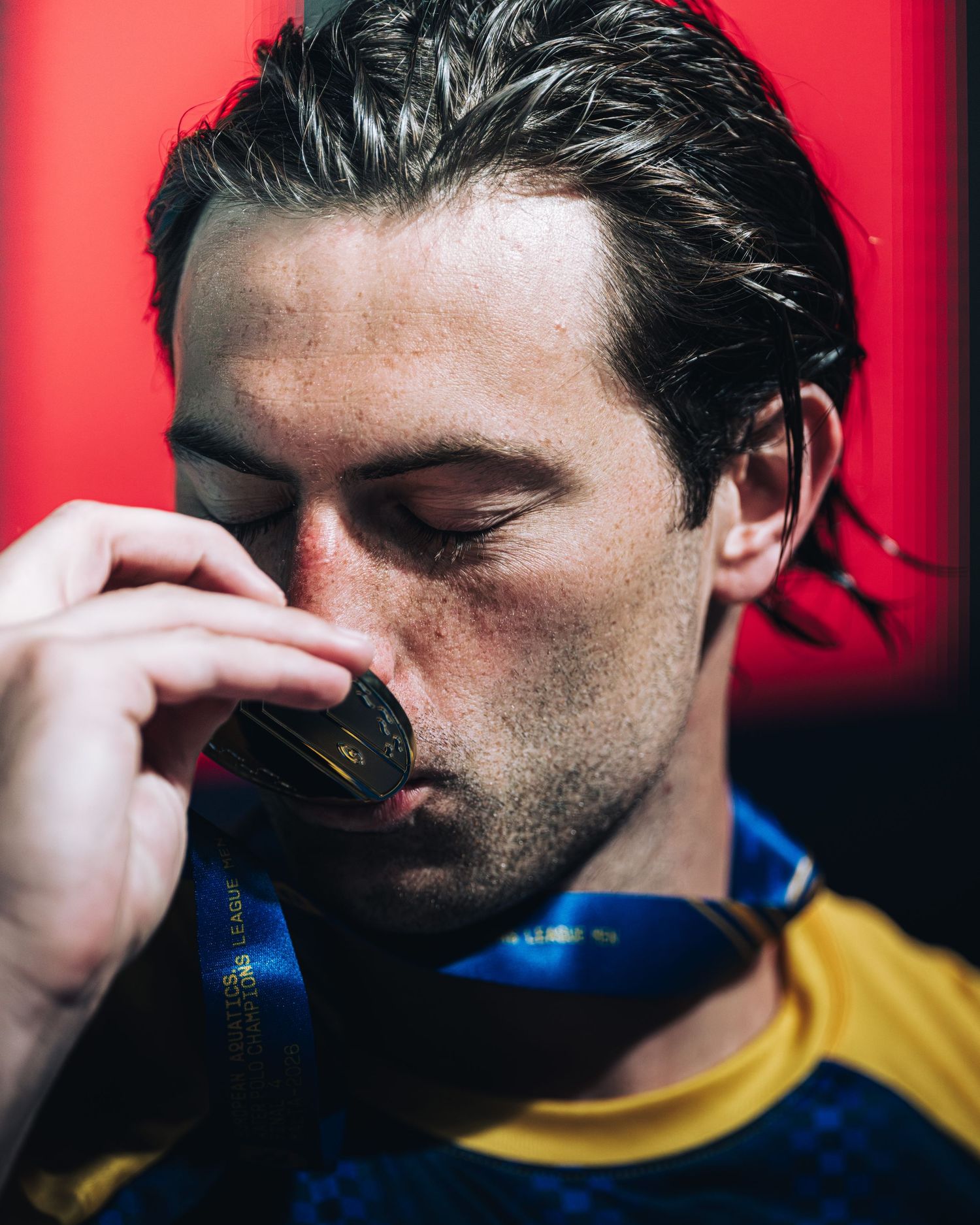 Athlete emotionally kisses gold medal in celebration after winning championship competition.