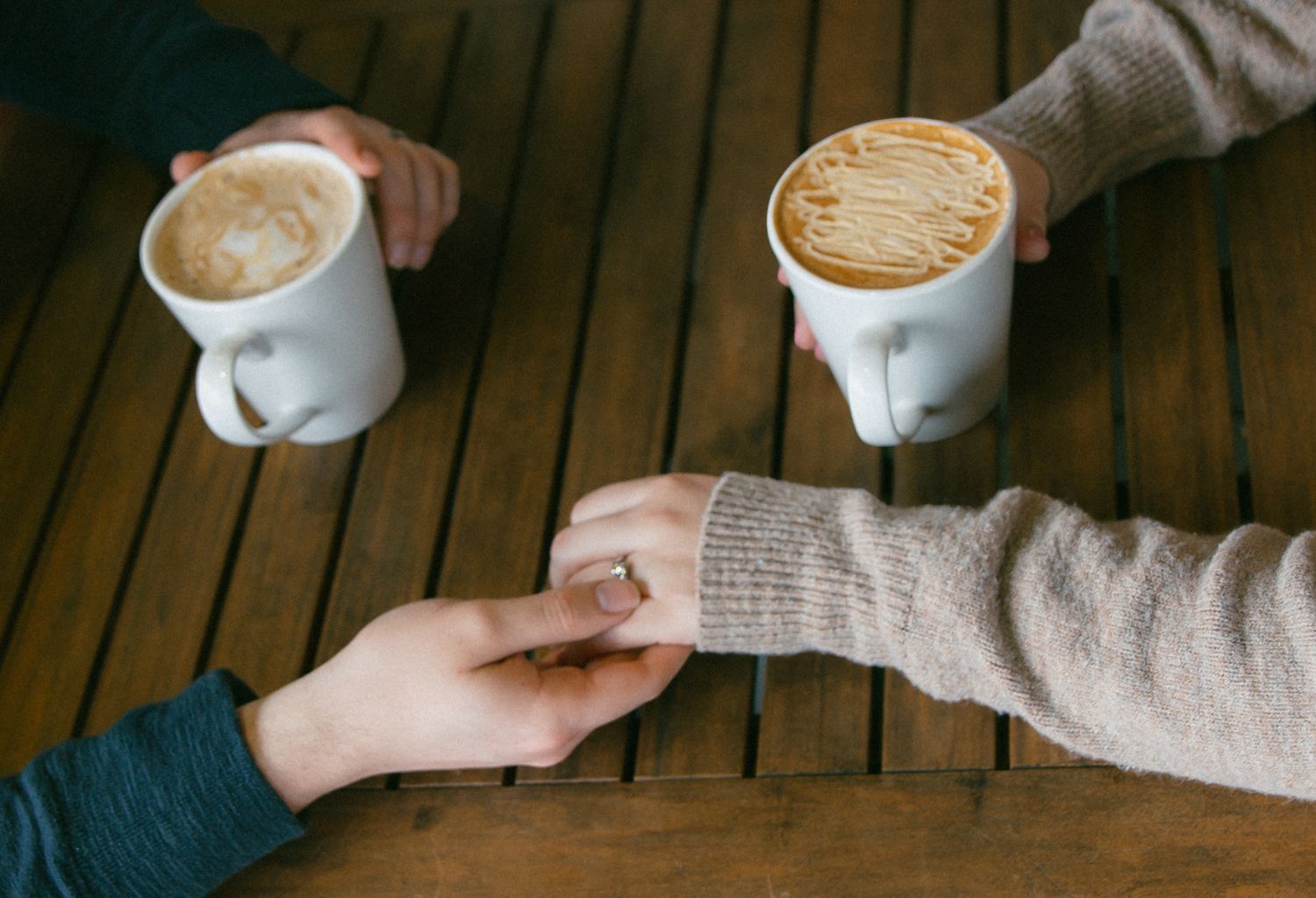A calm moment after engagment 
Newly engaged couple holding hands over coffee while celebrating a recent proposal in British Columbia.