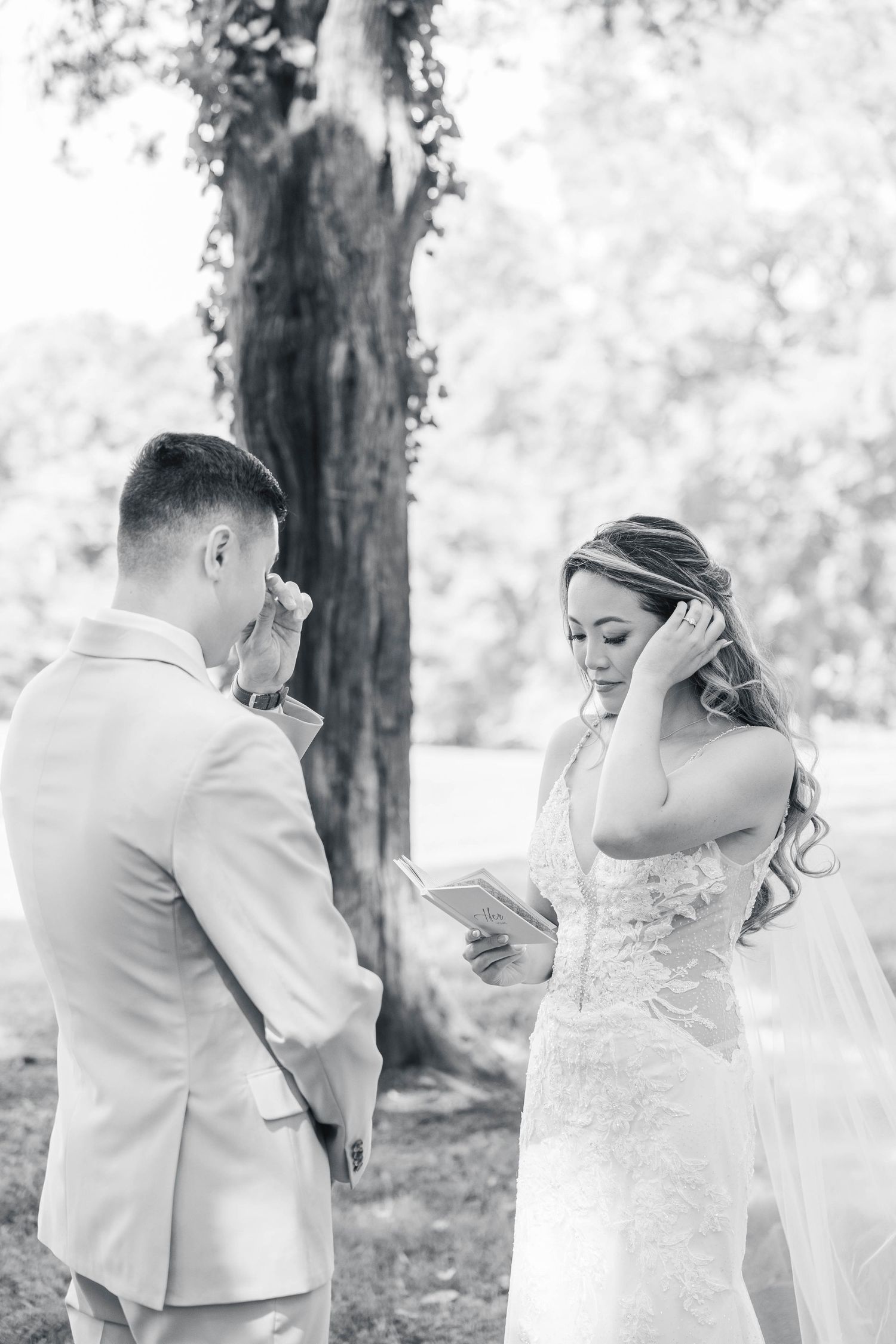 Emotional first look moment between bride and groom in a wooded outdoor setting.