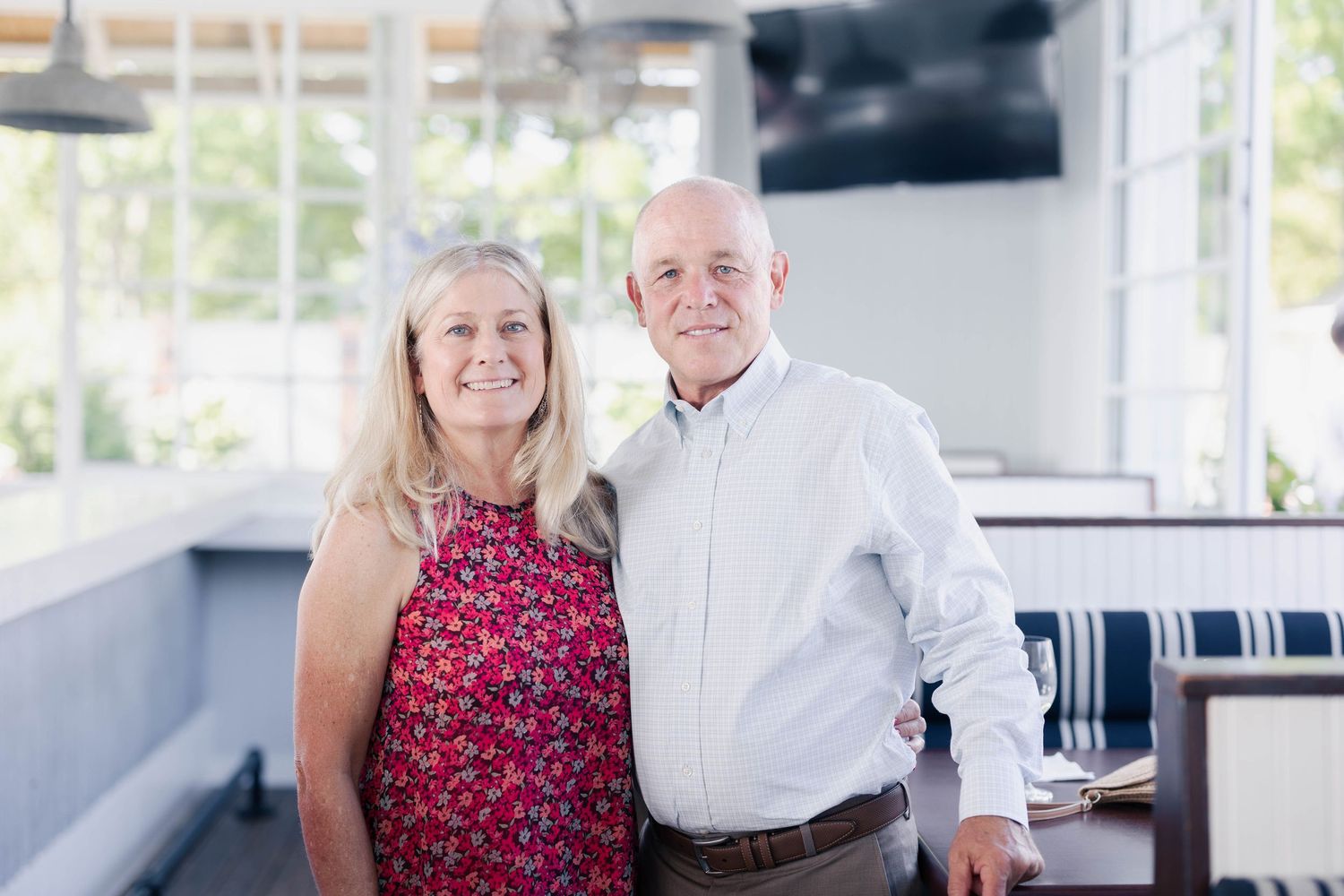 A couple in red and white attire smiling together in a bright indoor setting.