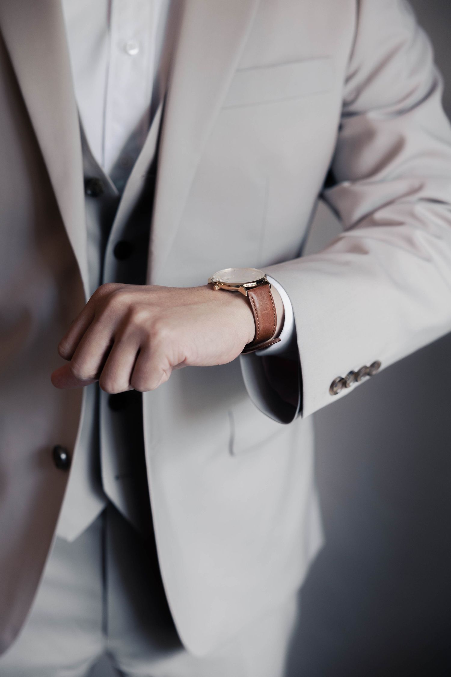 Detail shots of a light colored suit jacket and sleeve adjustments.
