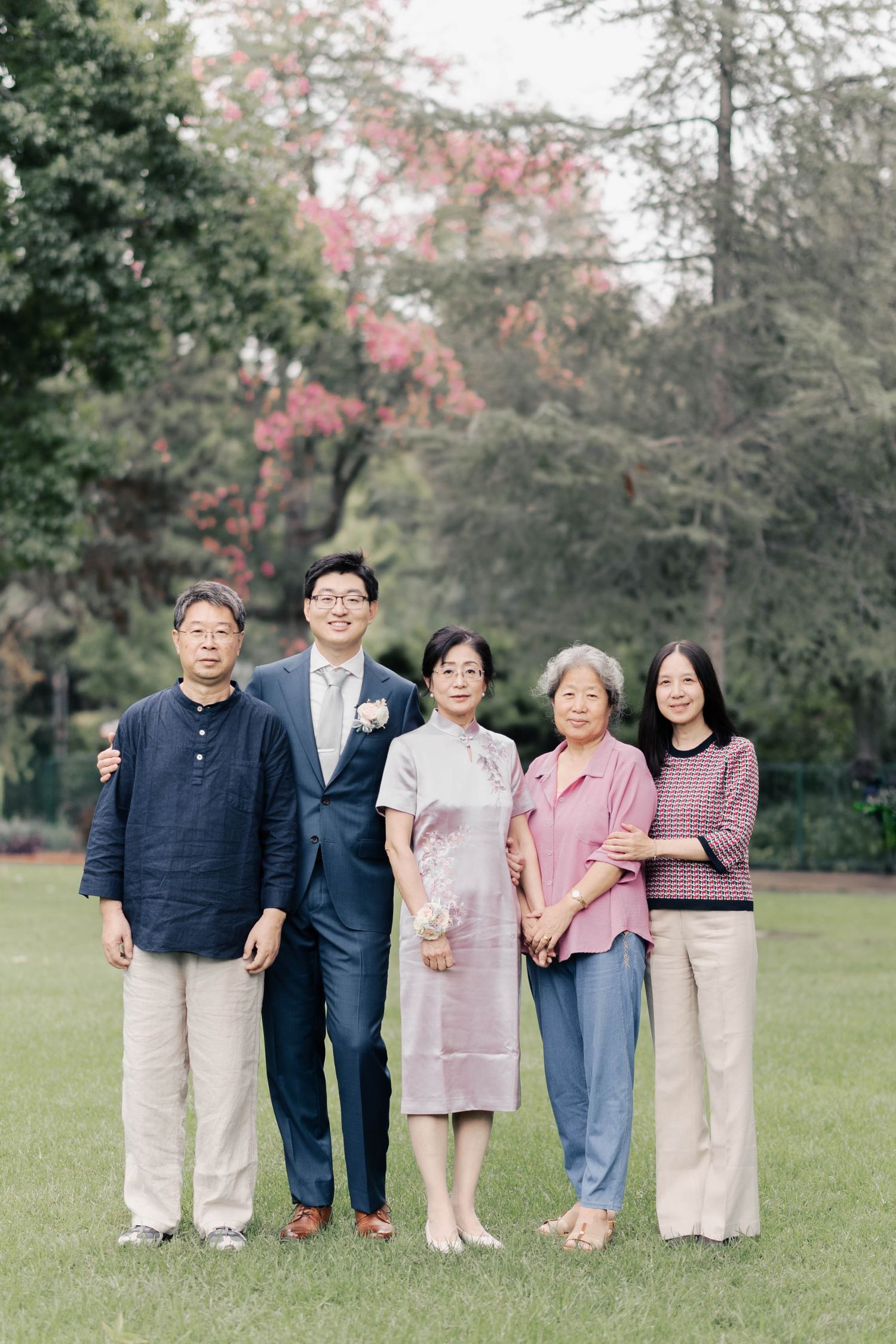 Wedding party group photo outdoors with family members wearing coordinated casual attire.