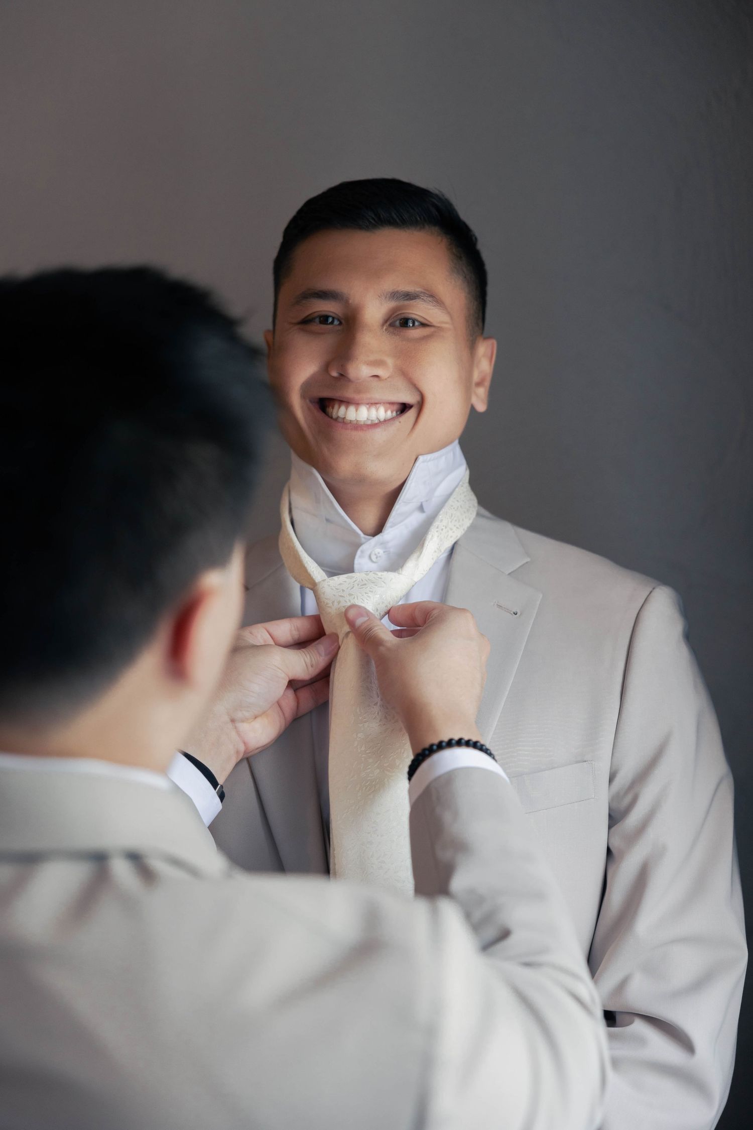 Close-up shots of someone adjusting a white bowtie while smiling.