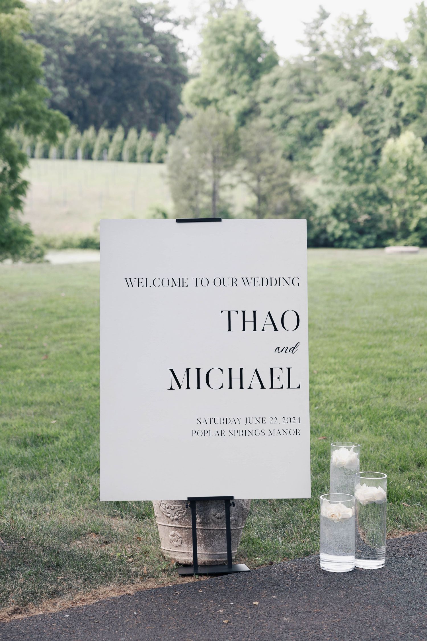 Elegant wedding welcome signs displayed outdoors with candle decorations.