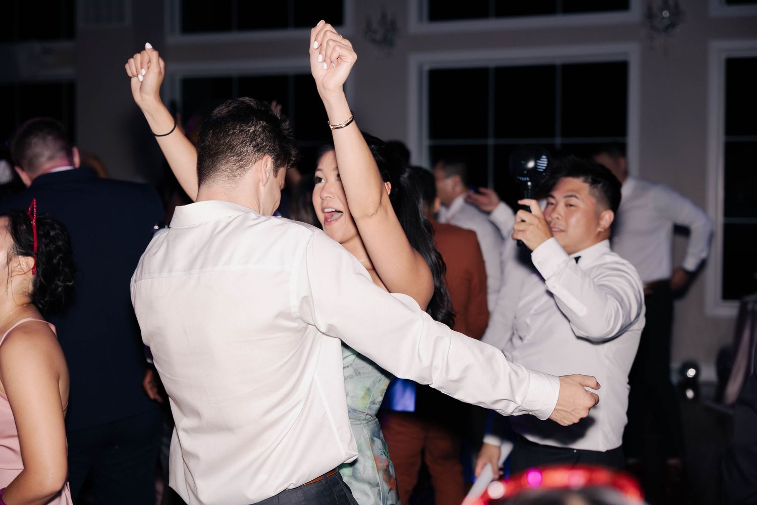 Guests dancing energetically at a wedding reception party in an elegant venue.