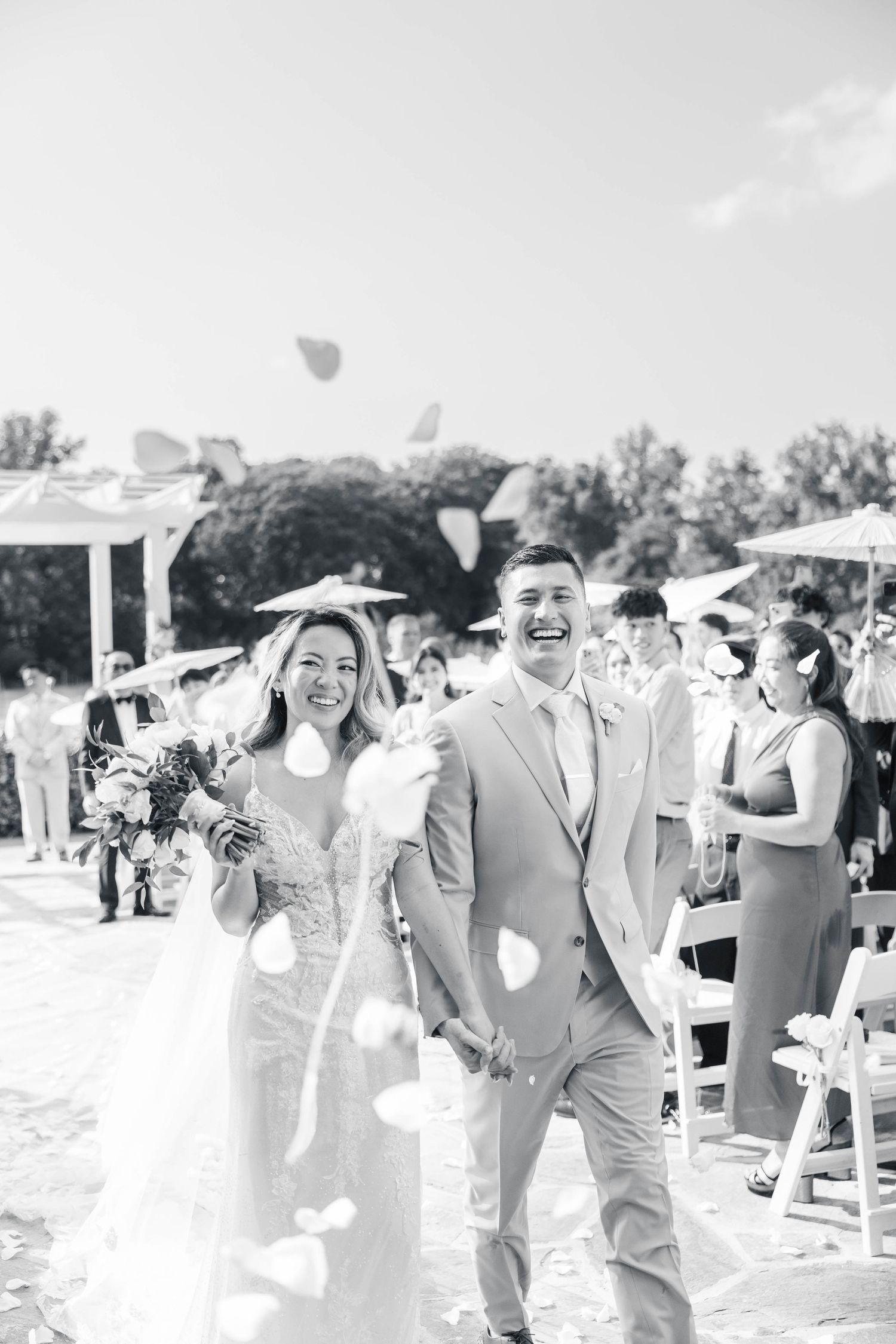 Wedding party celebrates with laughter and joy during outdoor ceremony procession.