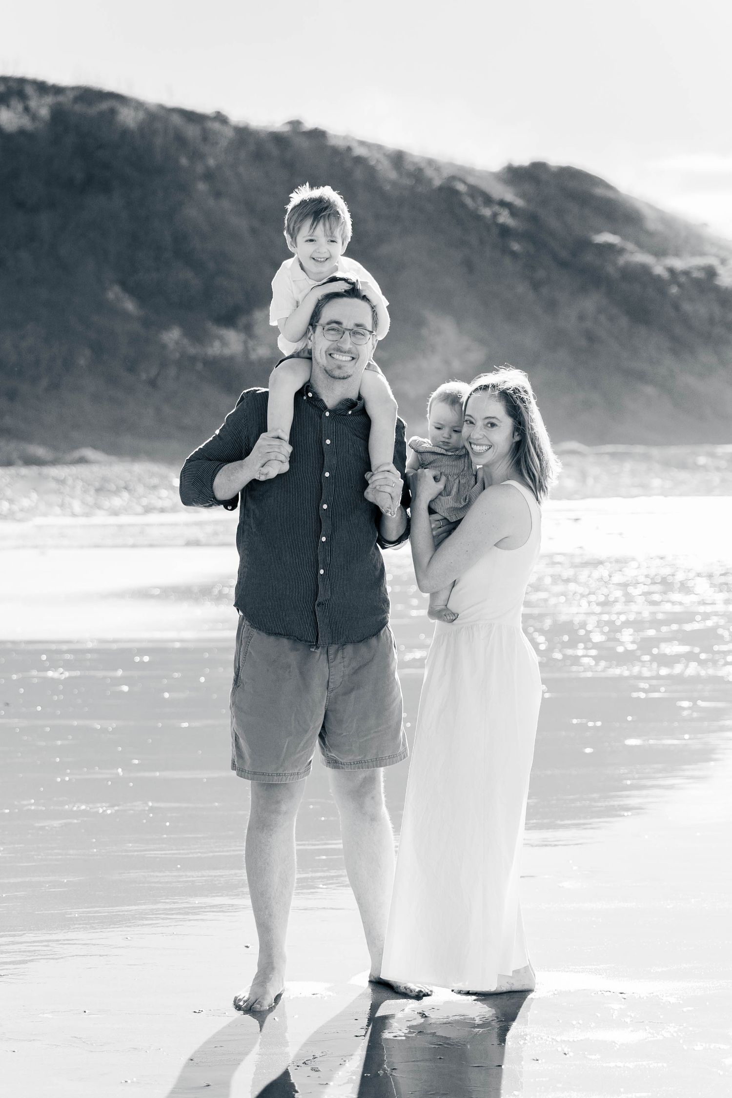 Couple enjoying a sunny day at the beach in black and white photography.