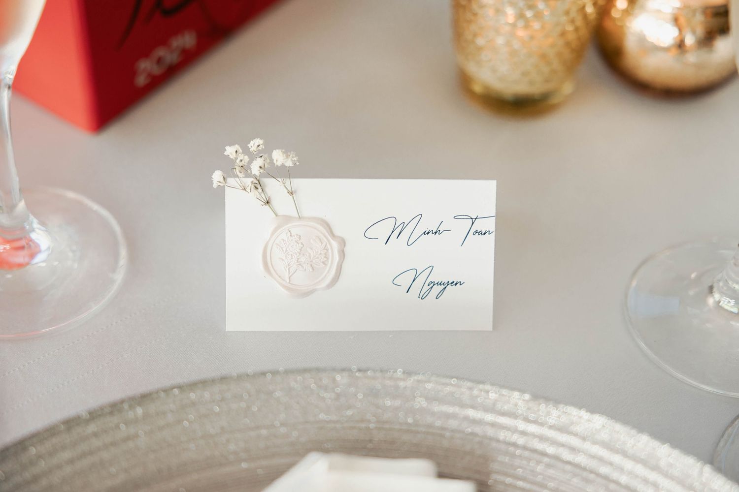 Elegant place settings with name cards and gold accents at wedding reception.