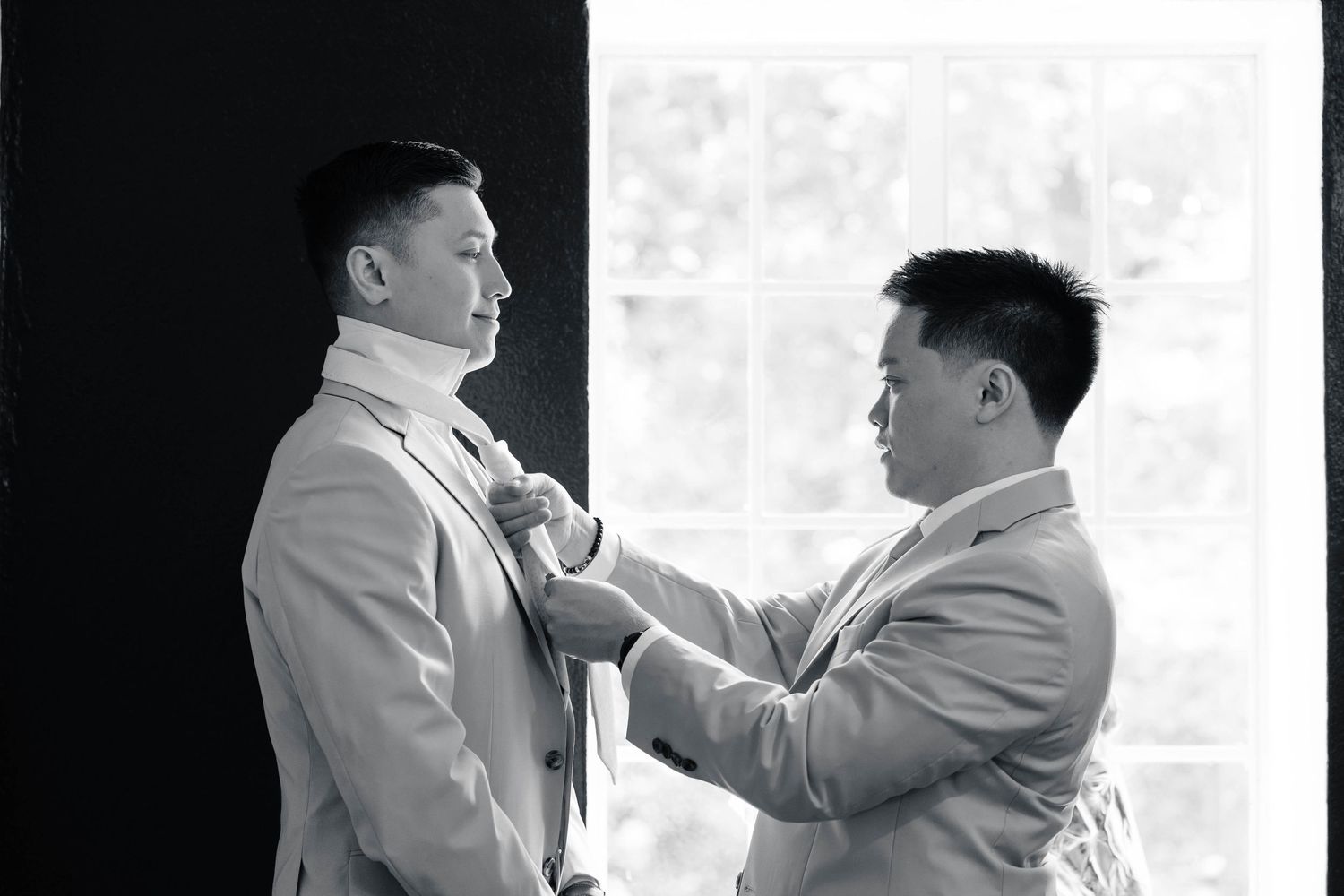 Two people in light colored suits sharing a moment together.