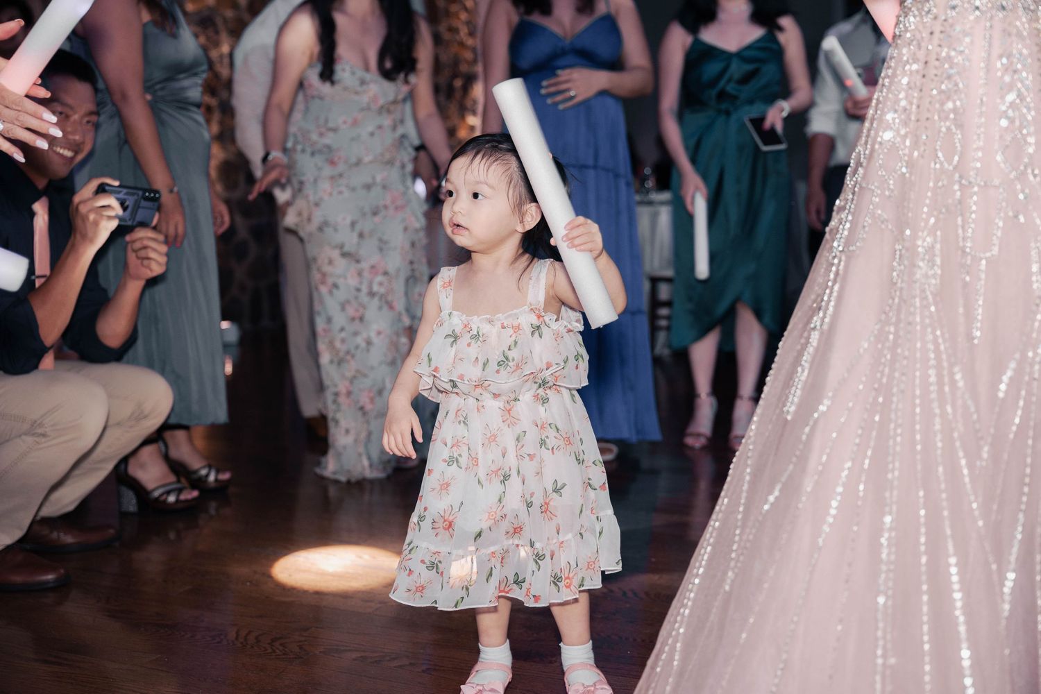 Wedding party dancing and celebrating in formal attire at an evening reception.