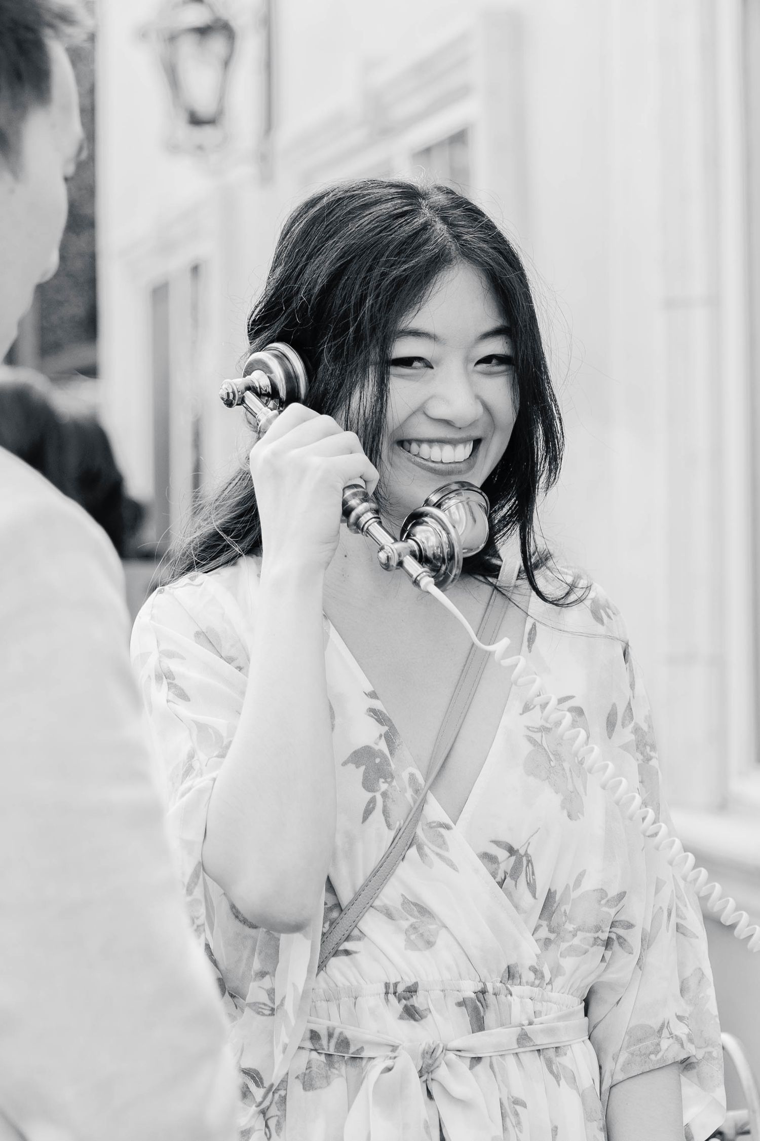 A series of black and white photos showing someone in a white dress laughing joyfully against a light background.