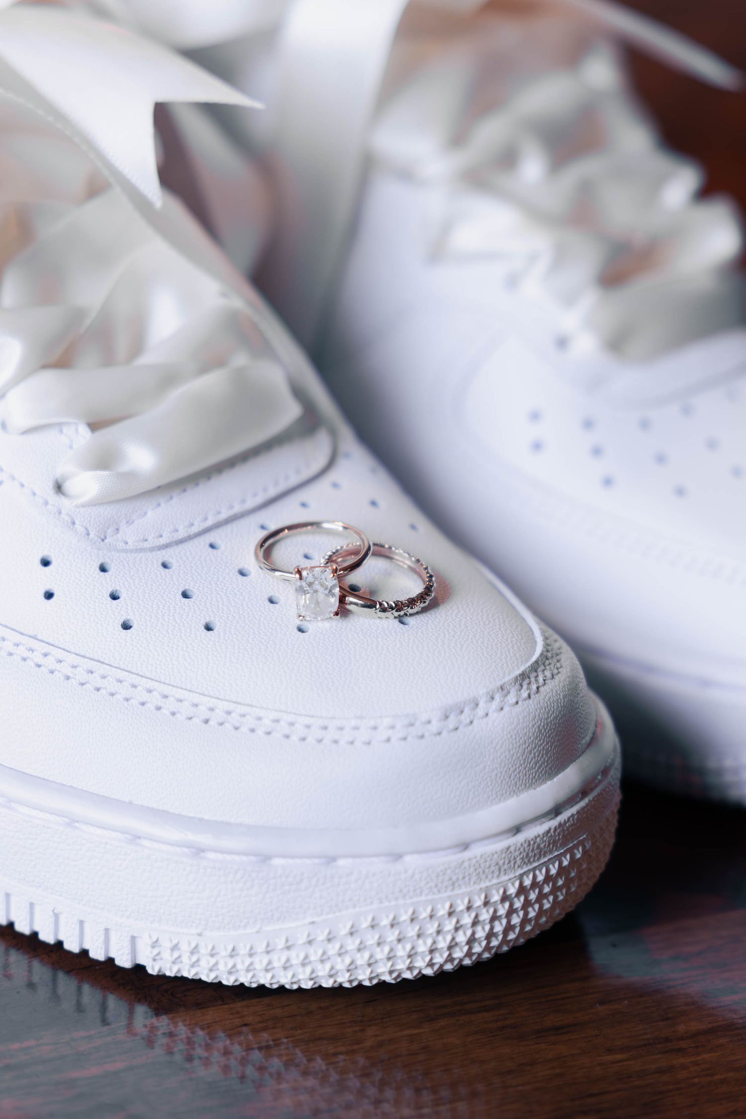 Close-up progression shots of white sneakers showing increasing detail and texture on wooden surface.