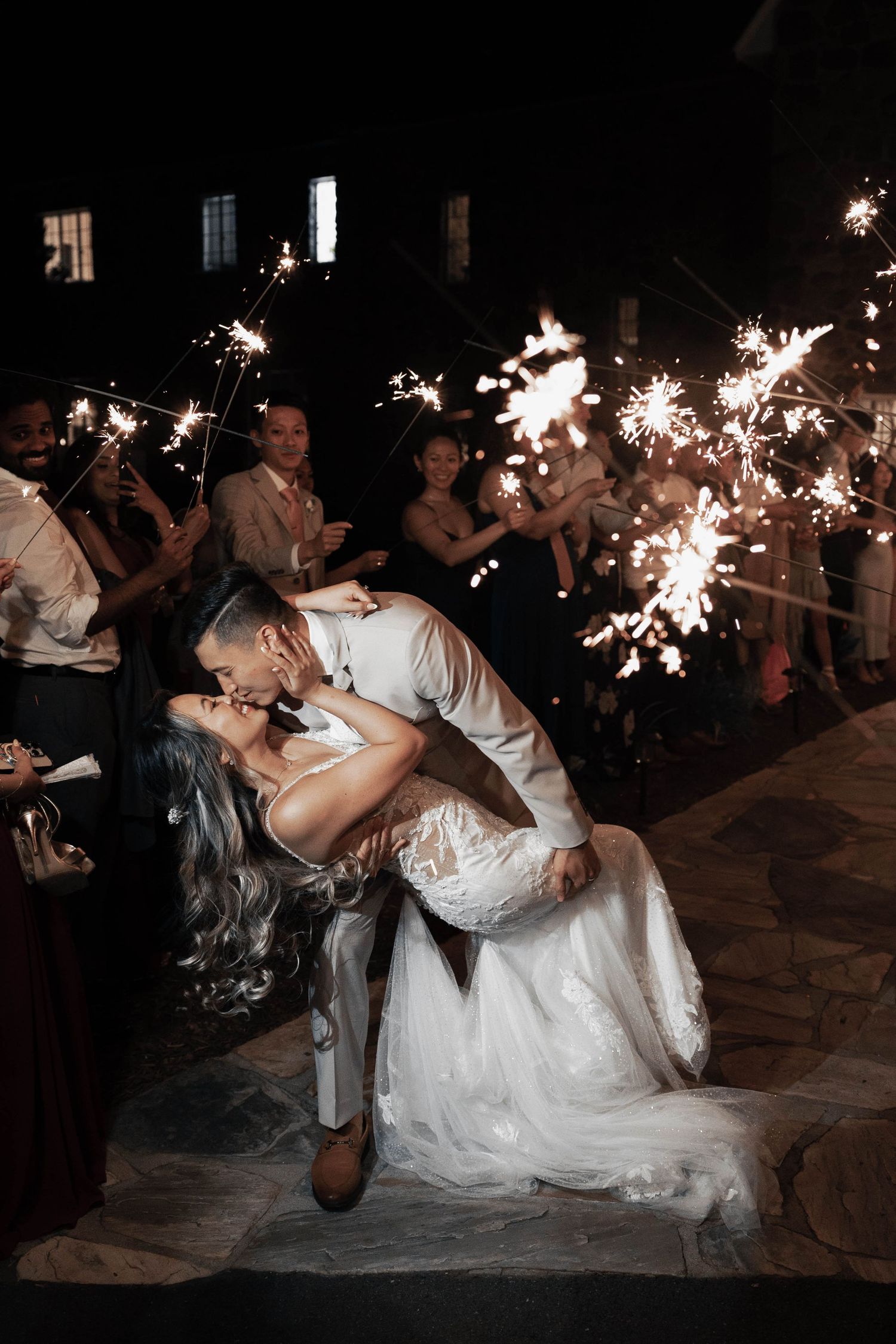 Sparkler-lit wedding dance finale with dramatic dip pose.