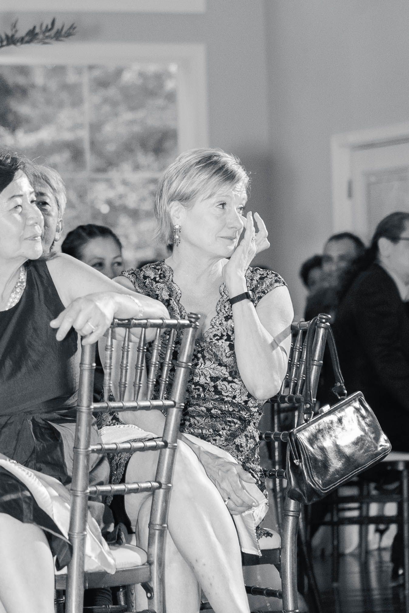 Wedding guests seated in formal chairs during an indoor ceremony.