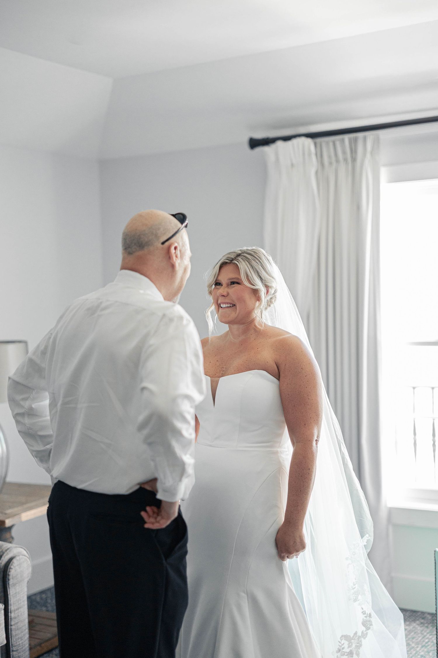 Multiple images show wedding dress preparations in a bright white room with flowing fabric and tulle details.