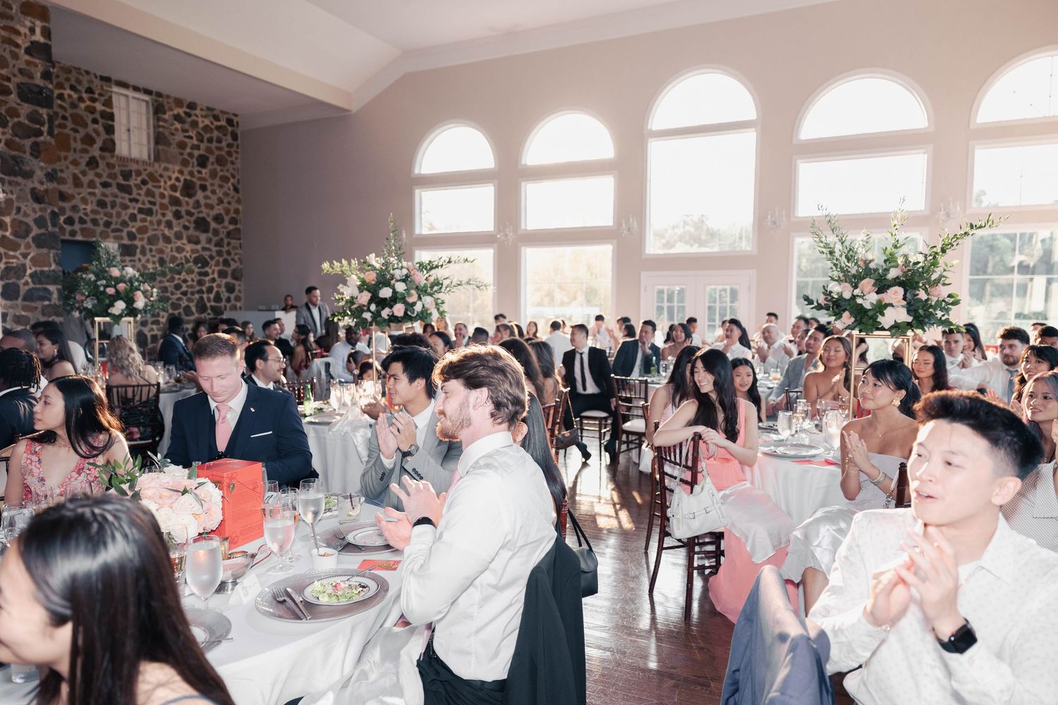 Bright reception venue filled with guests during celebration.