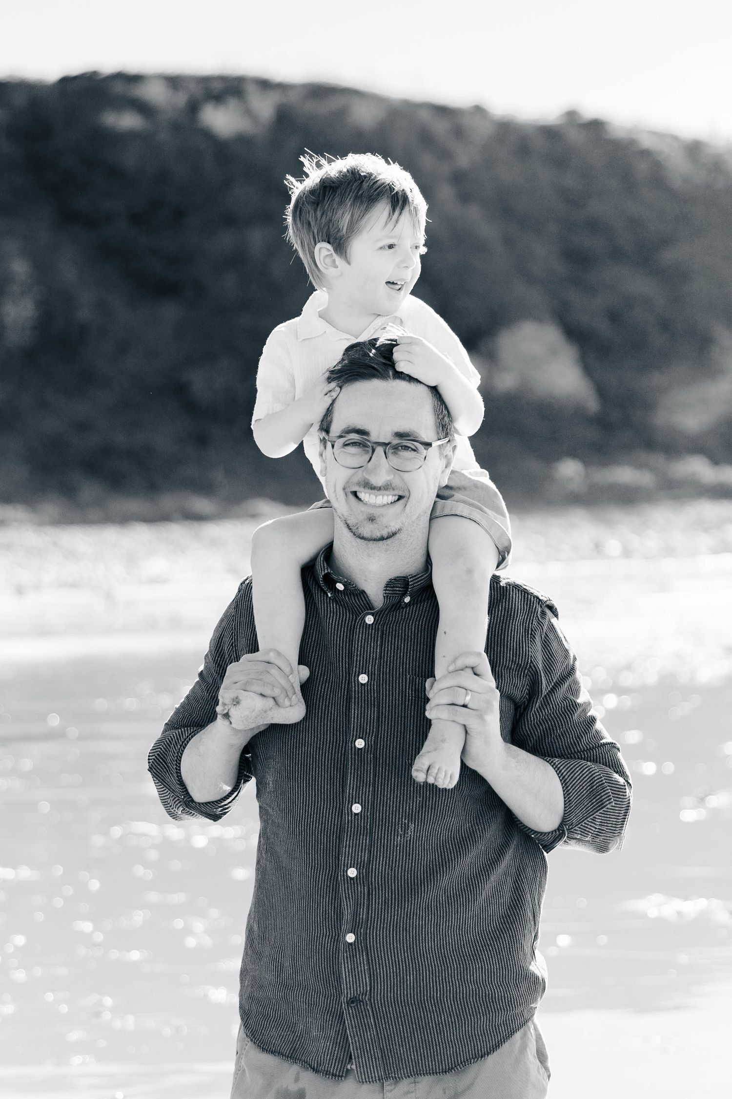 Black and white photos show a joyful moment between parent and child playing together at the beach.