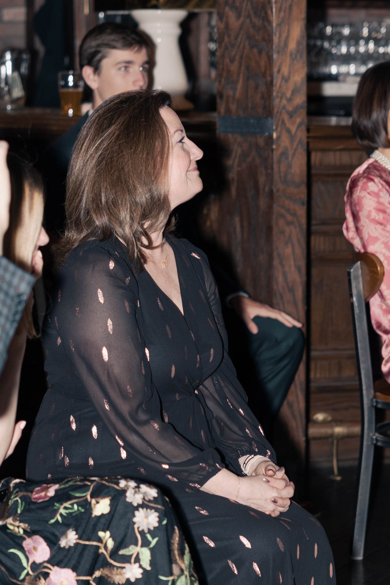 People gathered in a dimly lit bar or restaurant with brick walls and rustic decor.