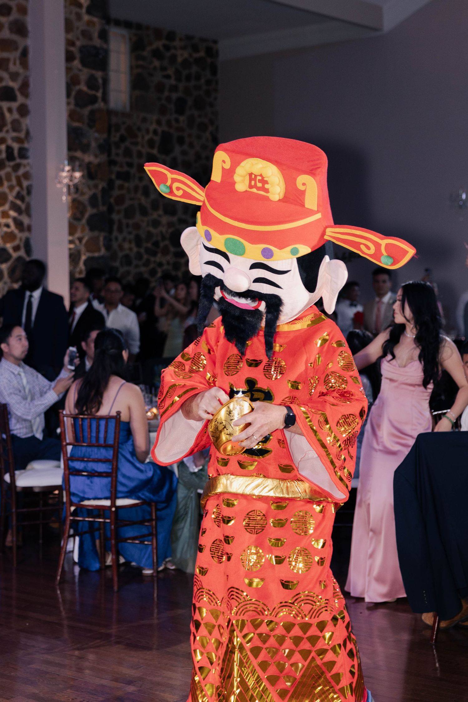 Traditional Chinese lion dance performers in bright red costumes entertain wedding guests.
