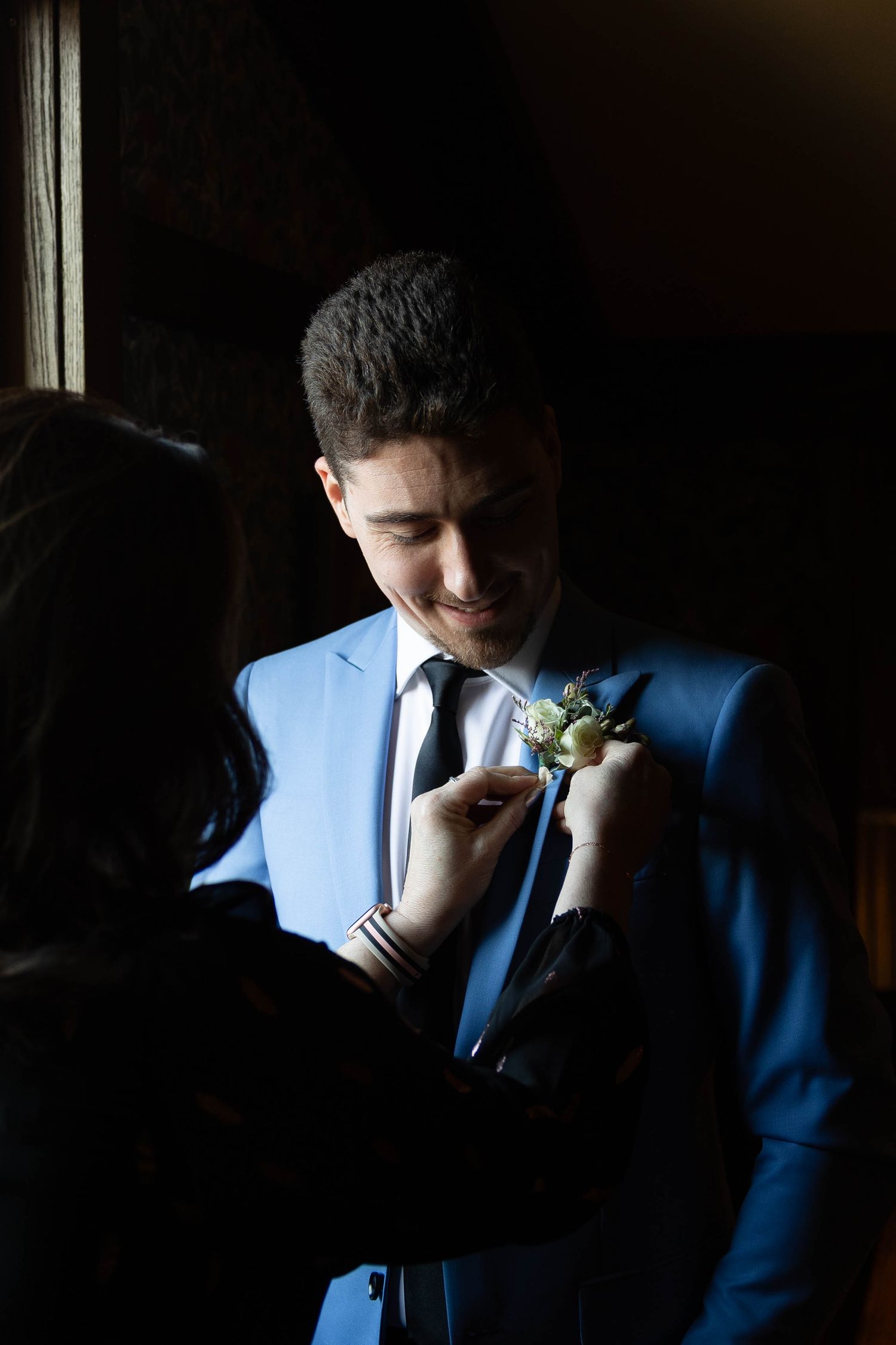 Artistic portrait series showing contrast between light and shadow on blue suited figure.