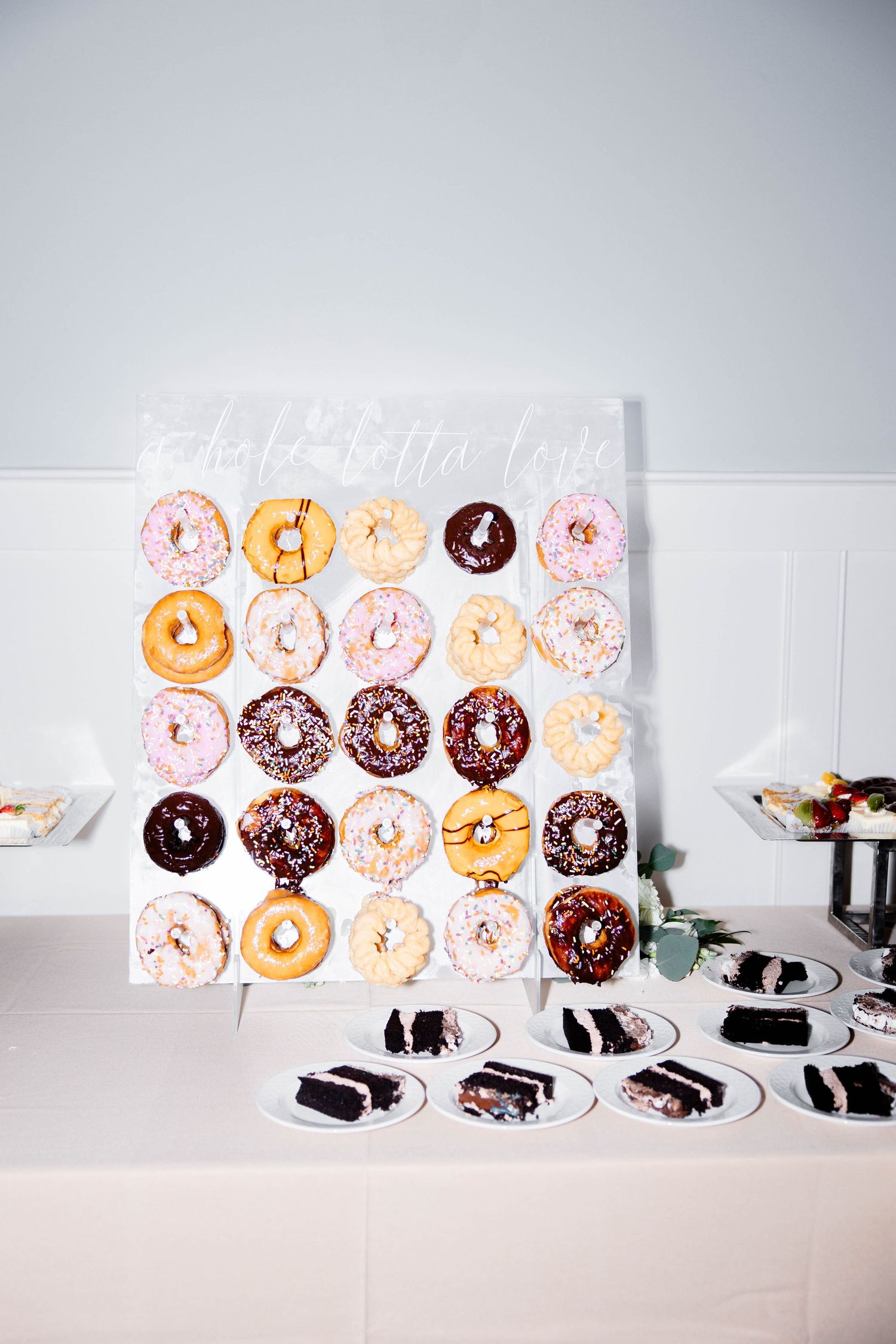 Artfully arranged donuts with chocolate and vanilla glazes displayed on a white surface.