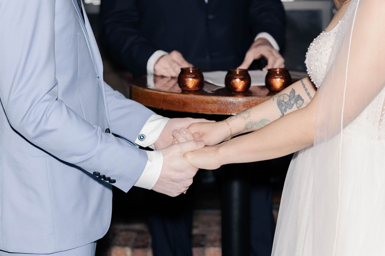 Close-up of hands exchanging wedding rings during a ceremony.