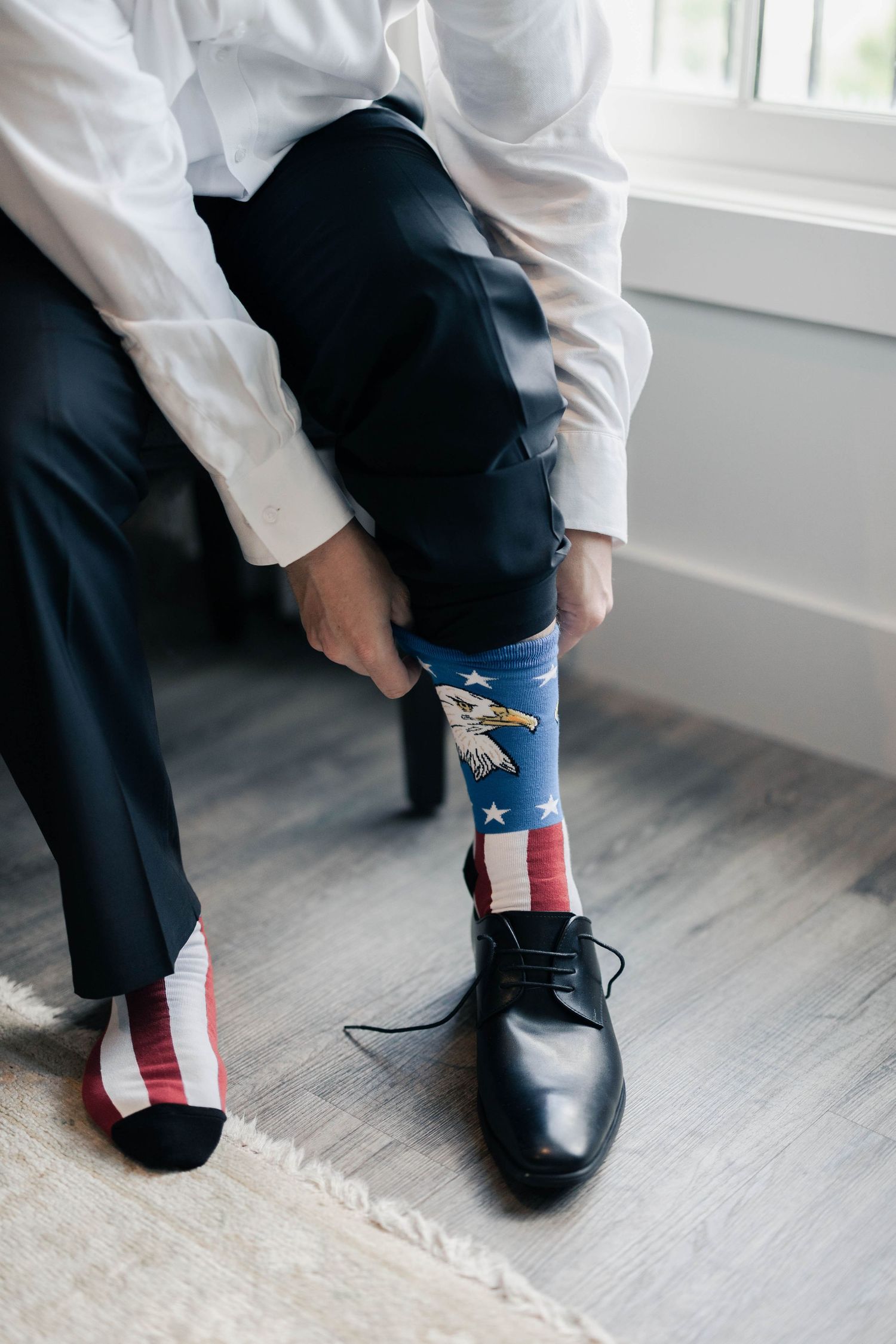 Wedding day detail of dress shoes and colorful patterned socks.