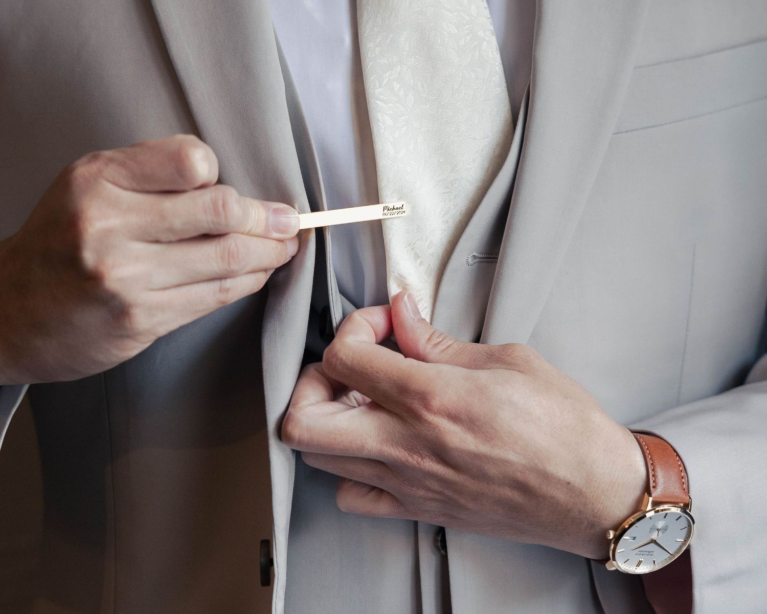 Detail shots of hands adjusting formal wear and accessories against a light background.