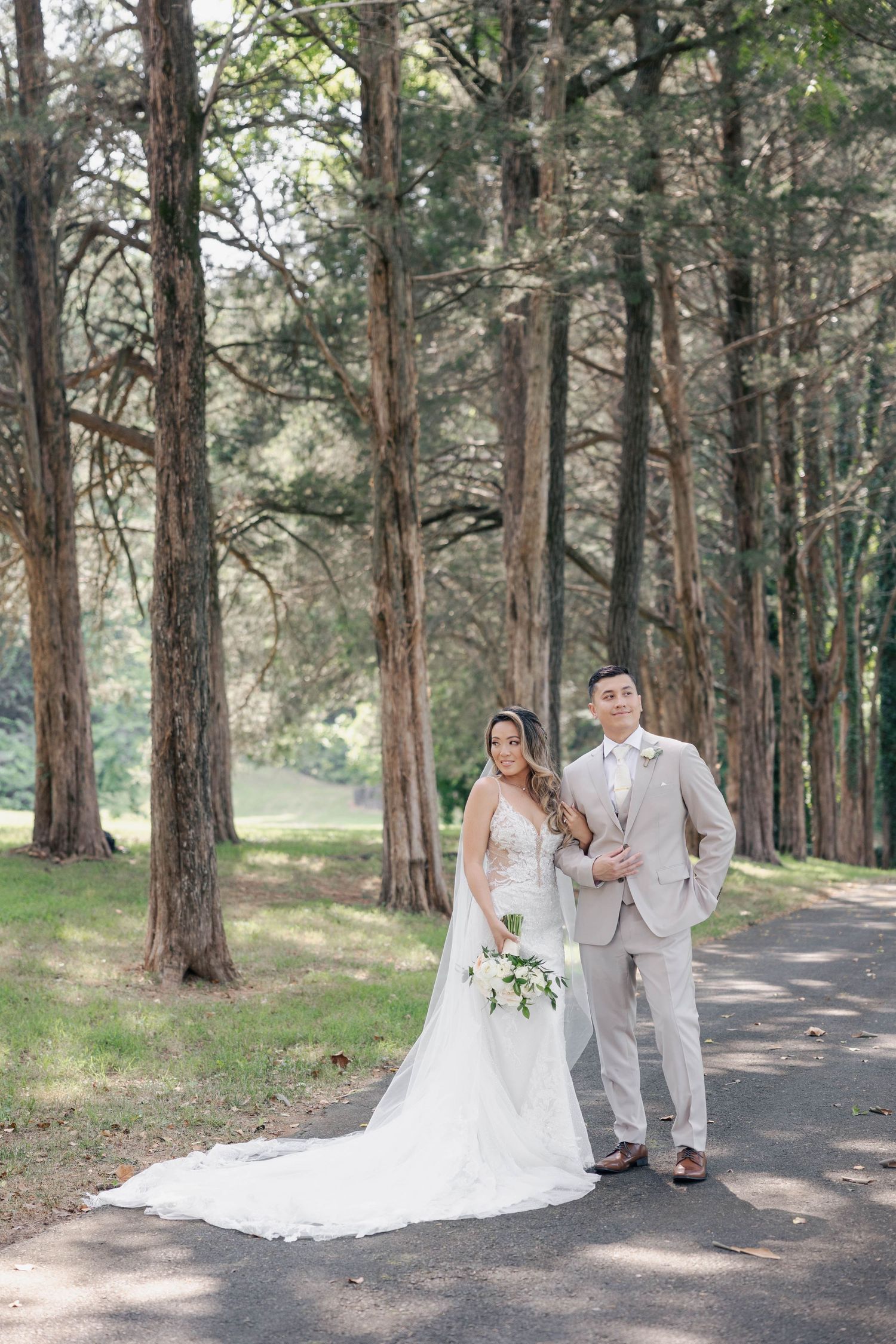 Wedding portraits captured on a serene forest path with tall pine trees.