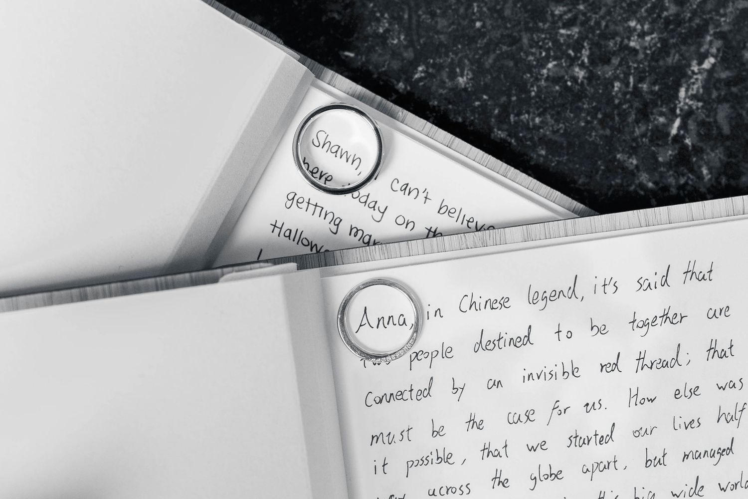 Handwritten notes and documents scattered across a dark surface showing partial text and writing.