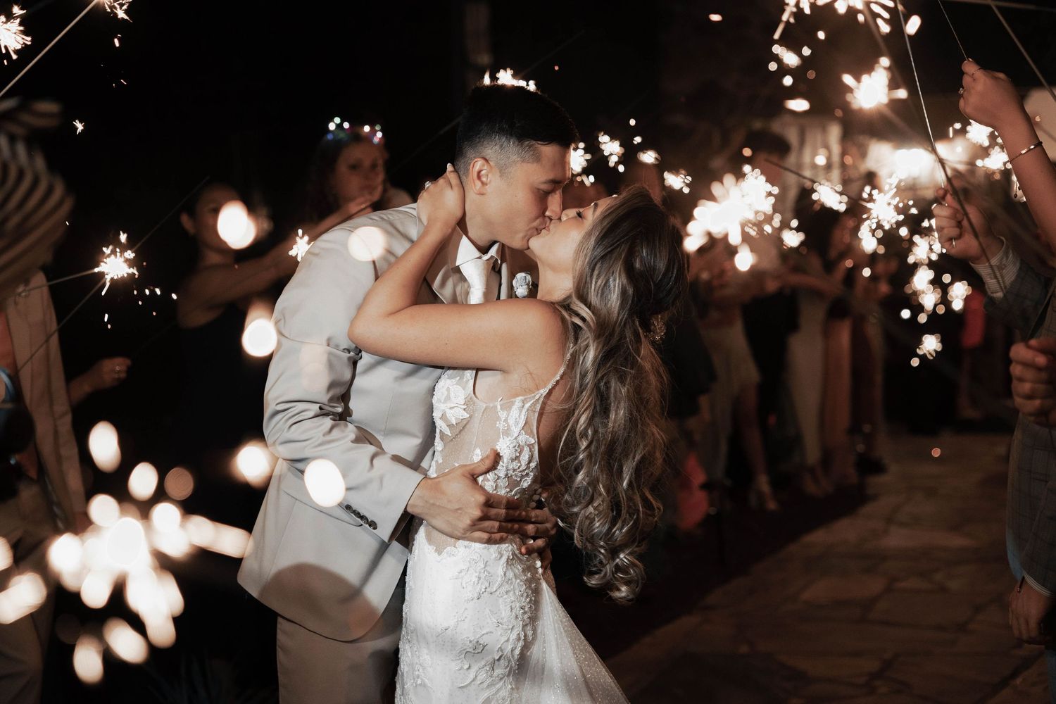 Wedding sparkler exit with guests creating a magical light tunnel.
