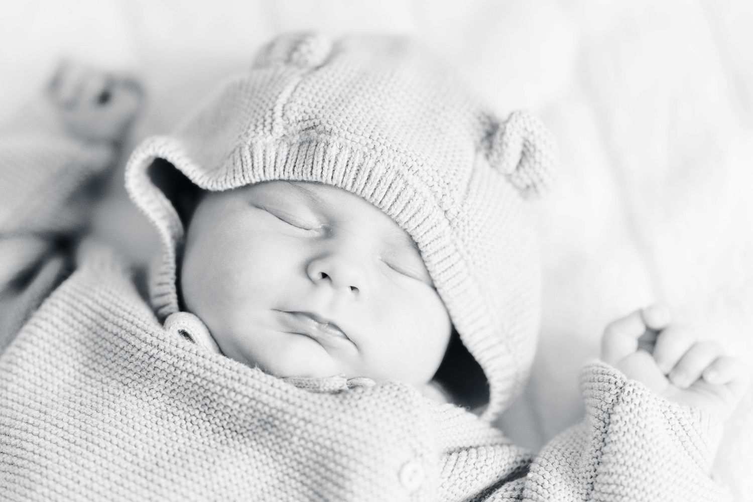 Peaceful closeup of a sleeping baby wearing a soft knit hat.
