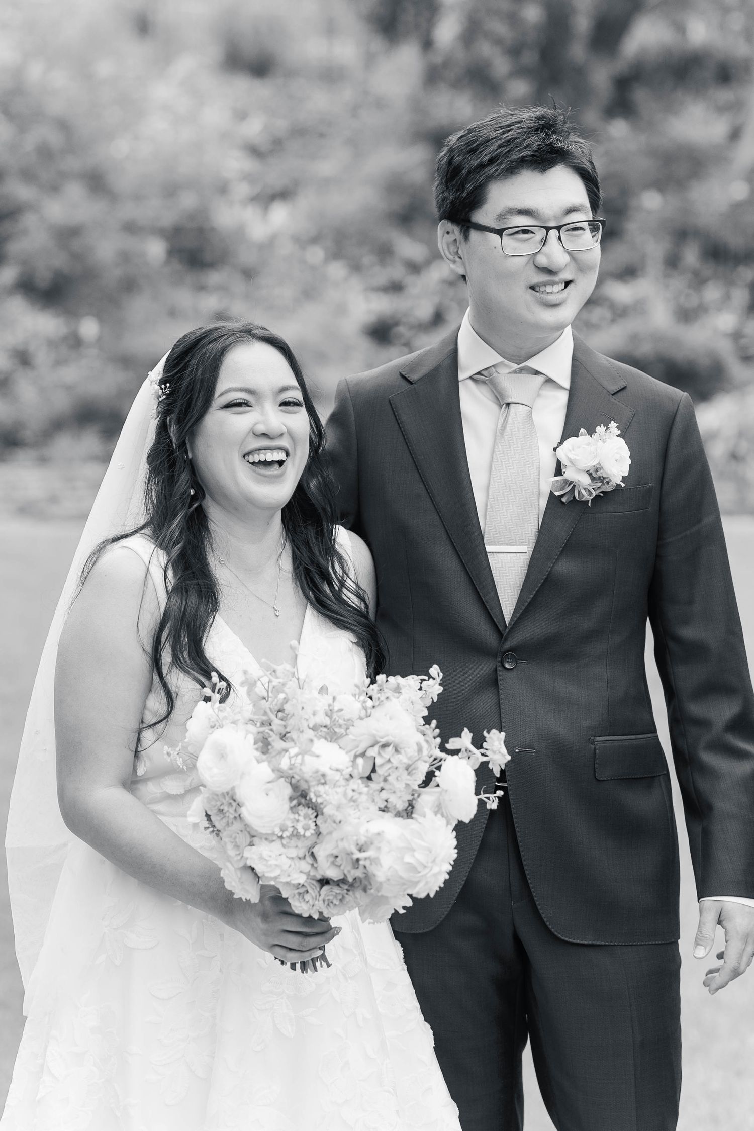A happy couple shares joyful moments together during their wedding photoshoot in an outdoor setting.