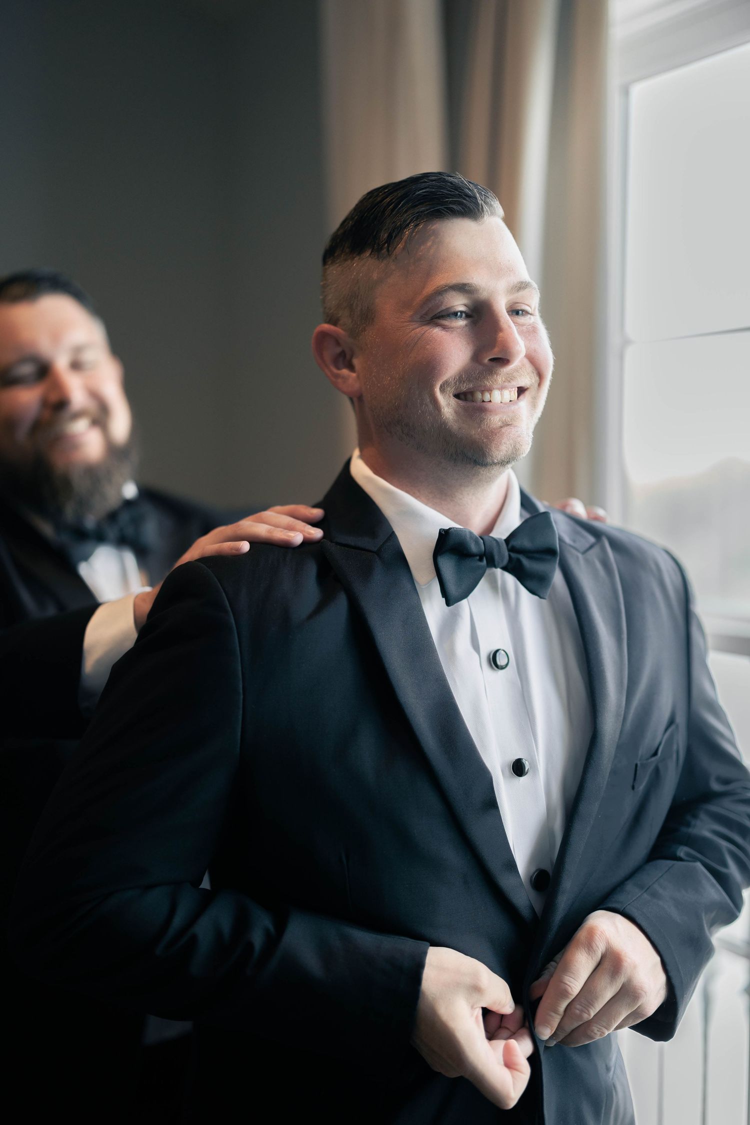 Wedding party members enjoying a lighthearted moment in formal attire.