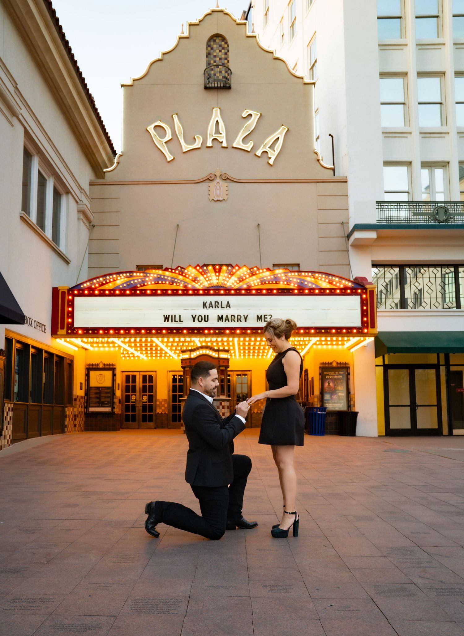 A series of five photos showing a marriage proposal sequence at a vintage movie theater marquee.
