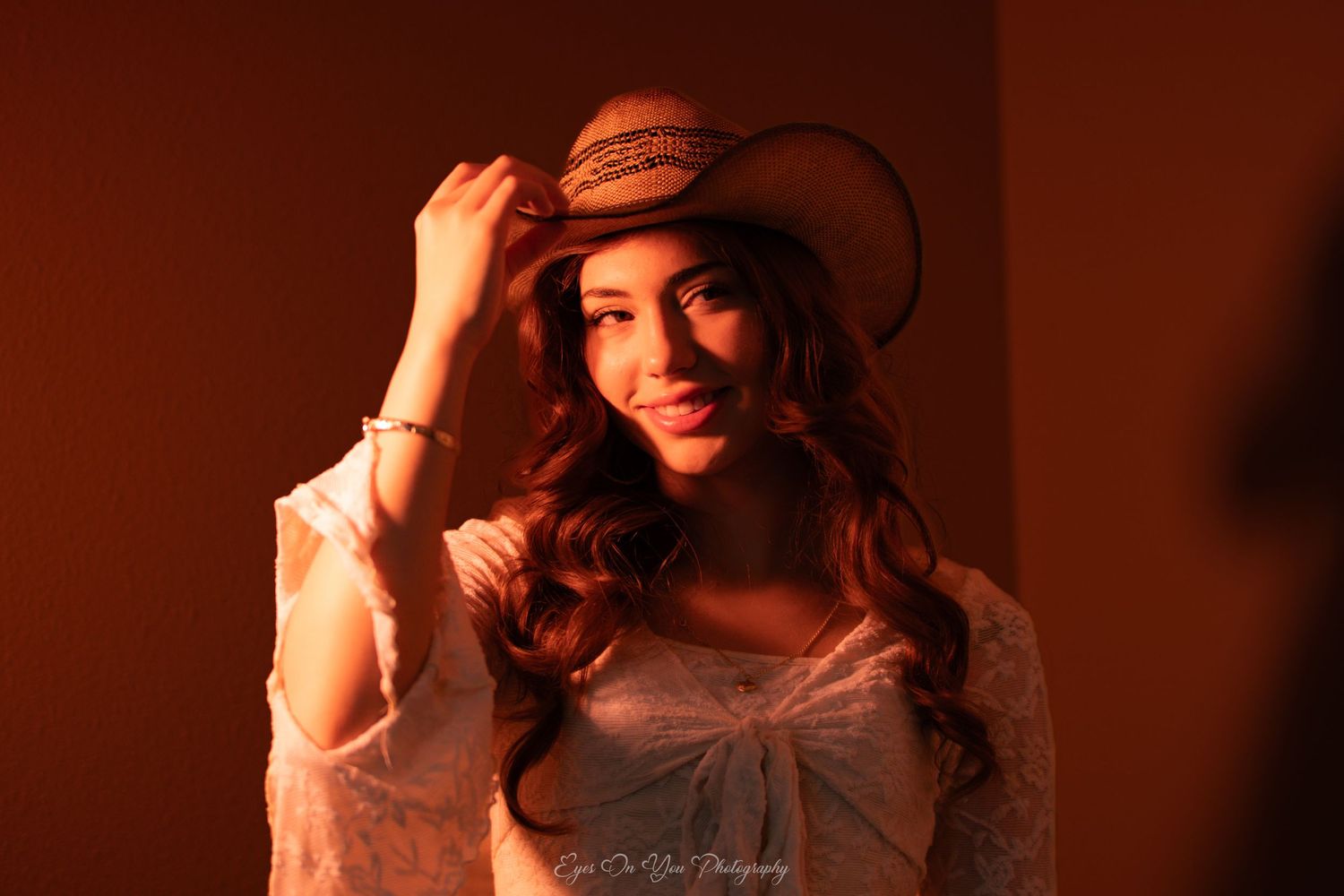 Artistic photo series in warm red tones featuring a western-styled portrait.
