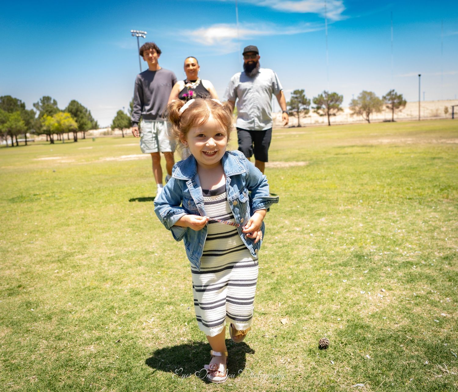 People enjoying a sunny day on green grass in an open field.