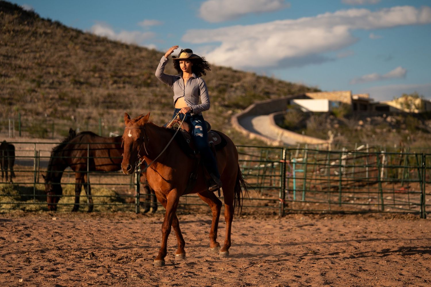 A sequence of western ranch scenes shows horseback riding and training in a dusty outdoor arena at sunset.