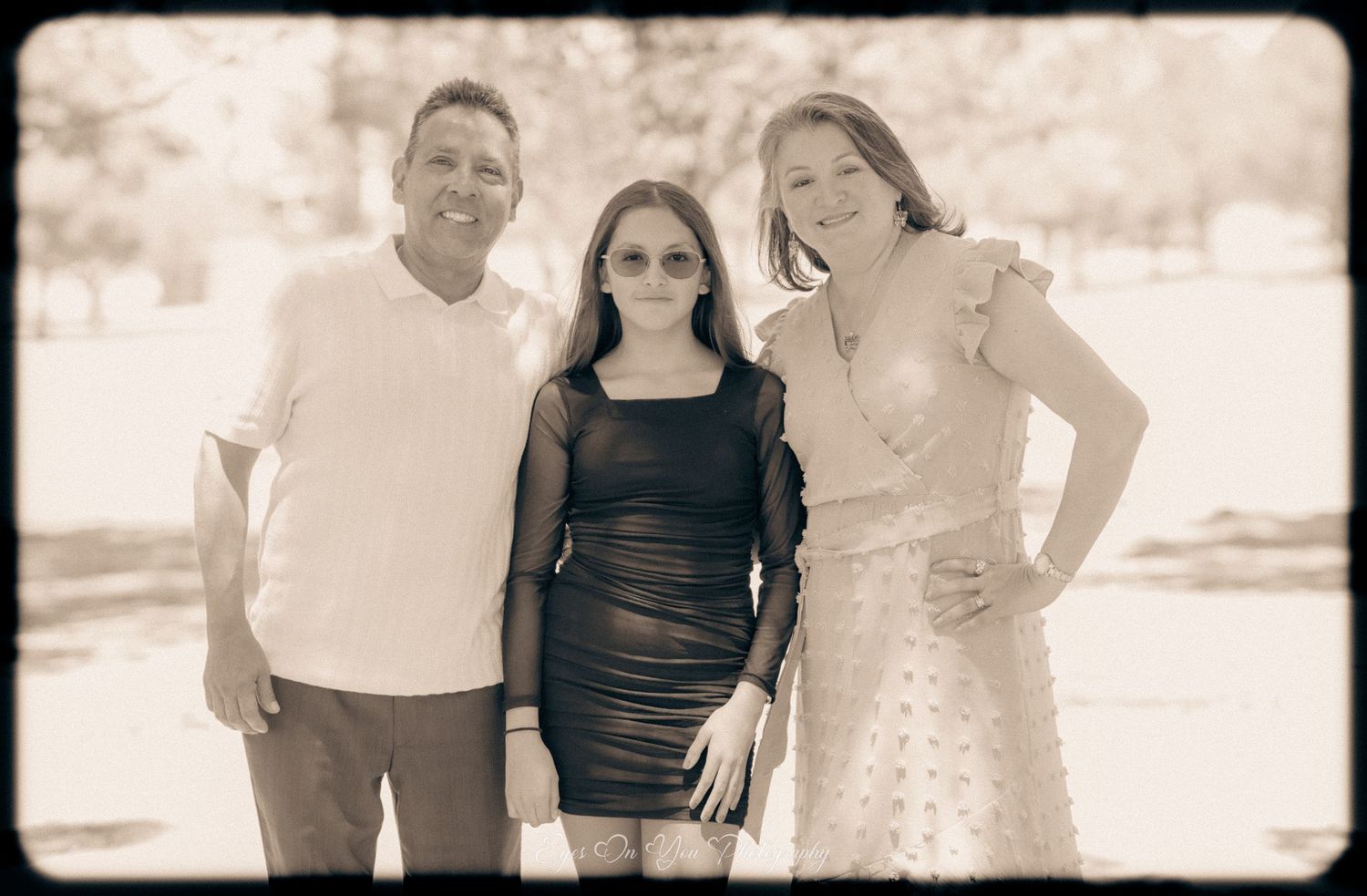Vintage-style sepia photograph of people posing outdoors in casual attire.