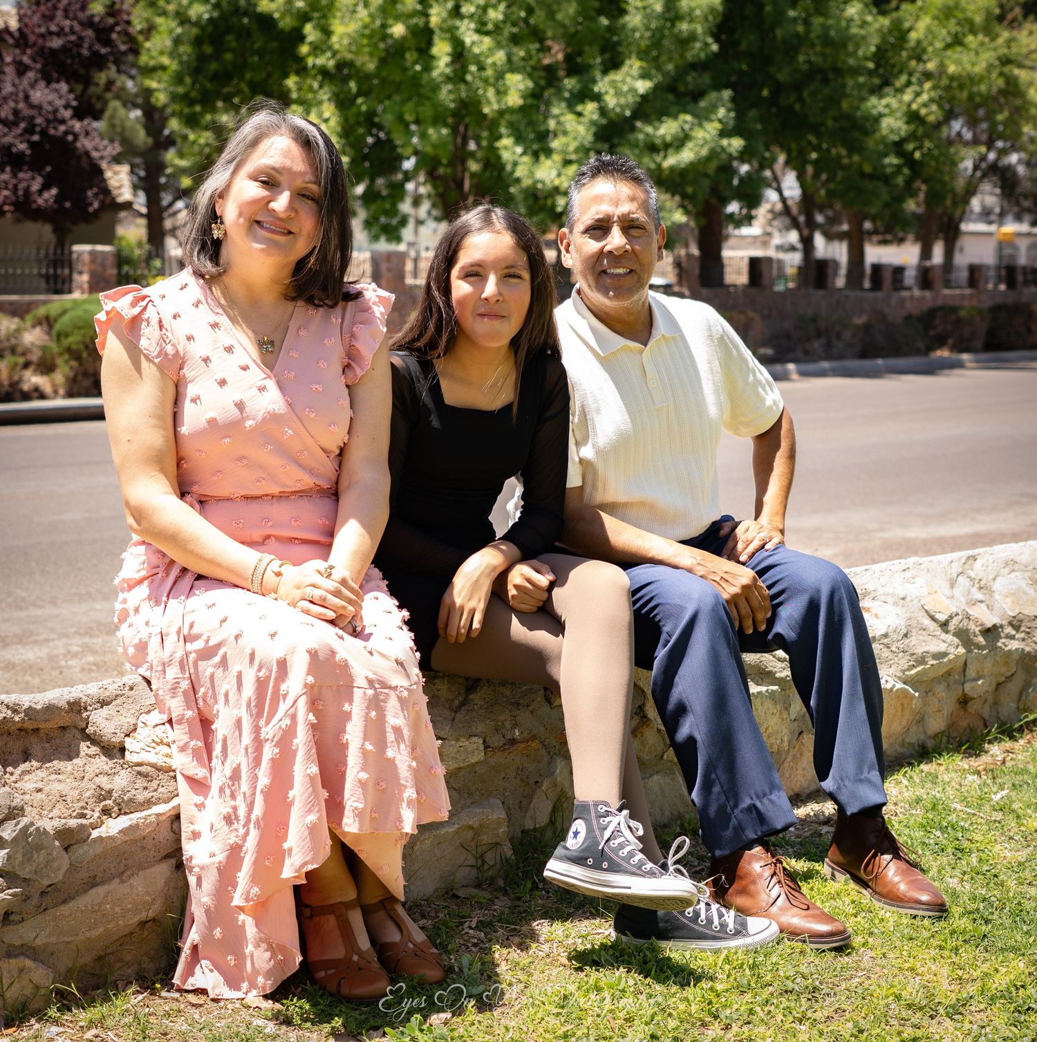 Group relaxing on grass during an outdoor photo session in a park setting.