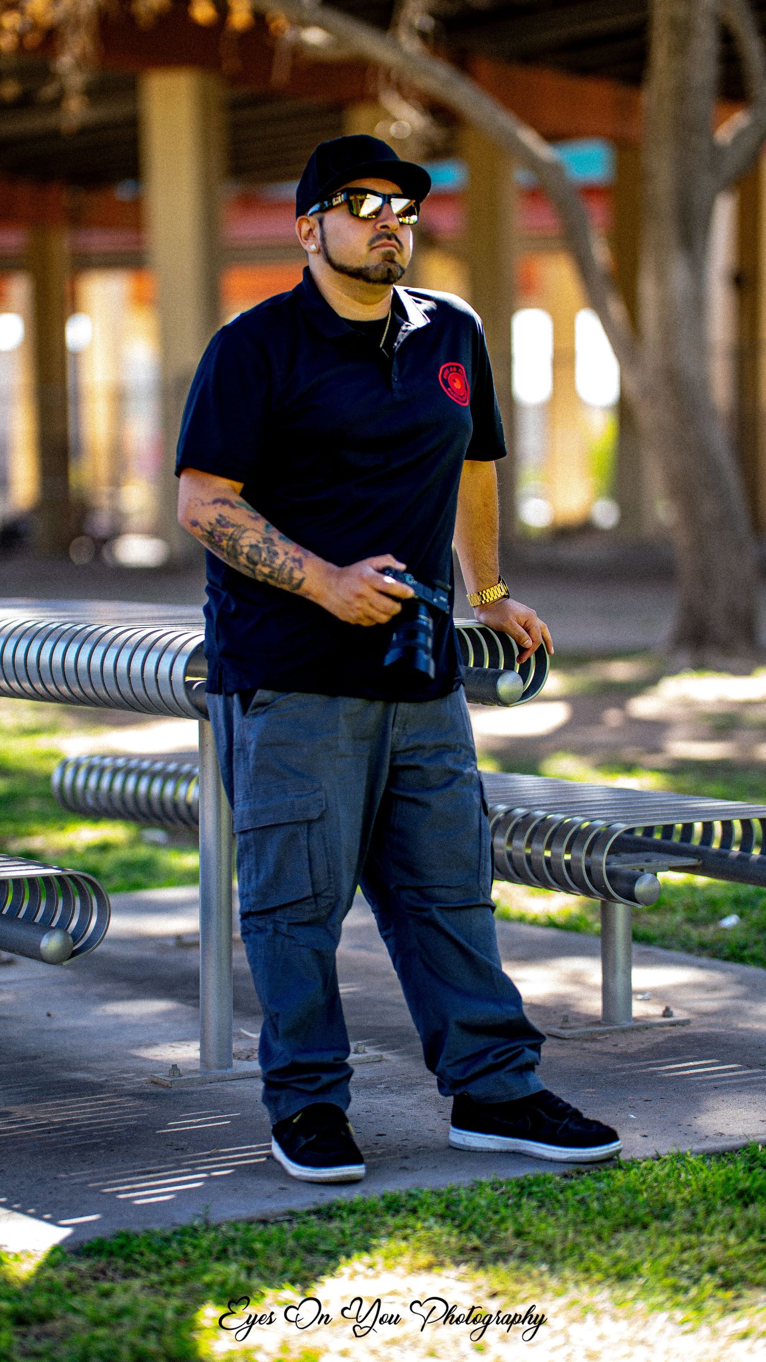 Person resting on curved metal bench in casual urban setting.