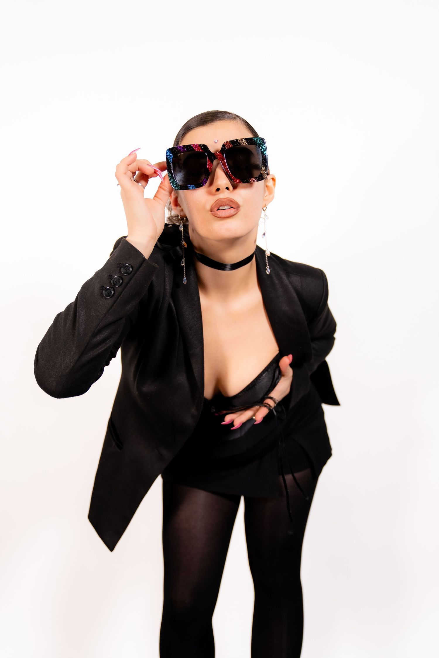A figure in a black blazer and sunglasses strikes three dynamic poses against a white background.