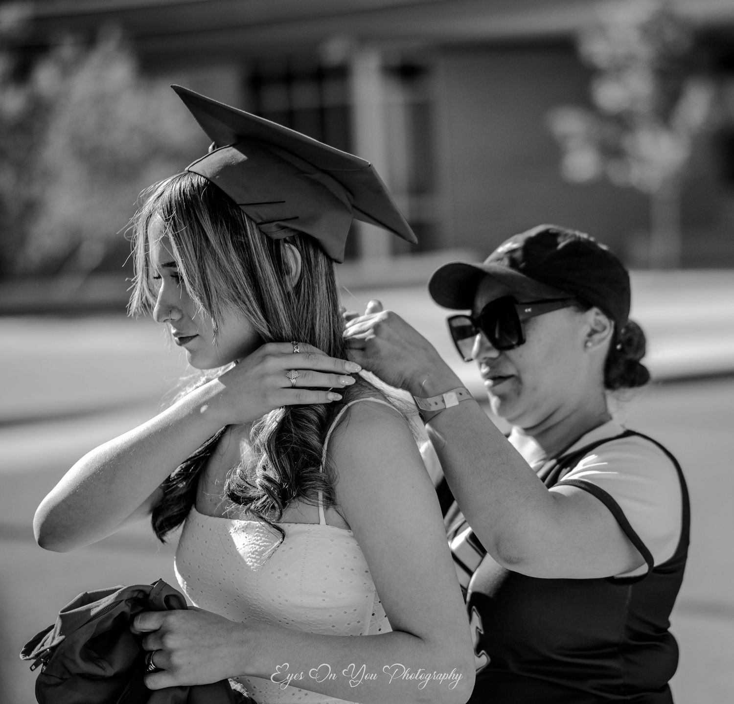 Black and white photo capturing emotional graduation embraces.