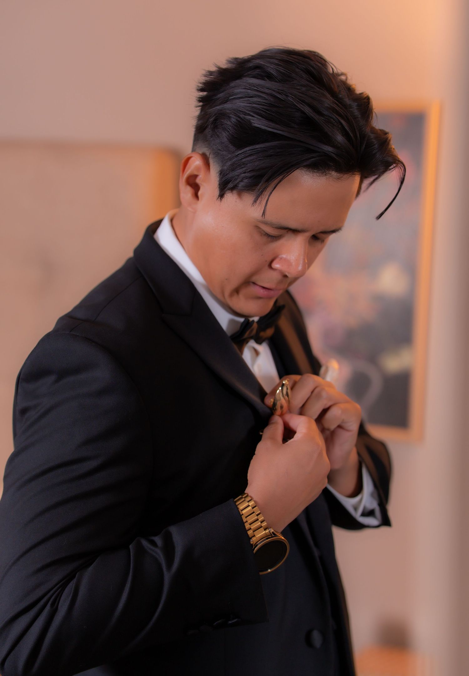 Professional in black suit adjusts tie in sequence of elegant poses against blurred background.